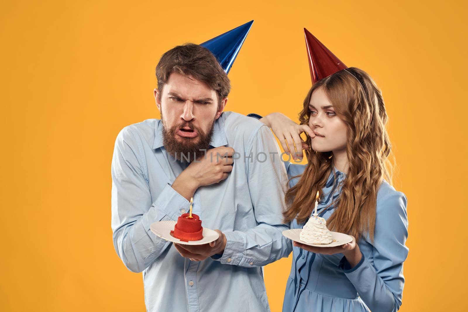 Birthday party man and woman fun yellow background cap holiday. High quality photo
