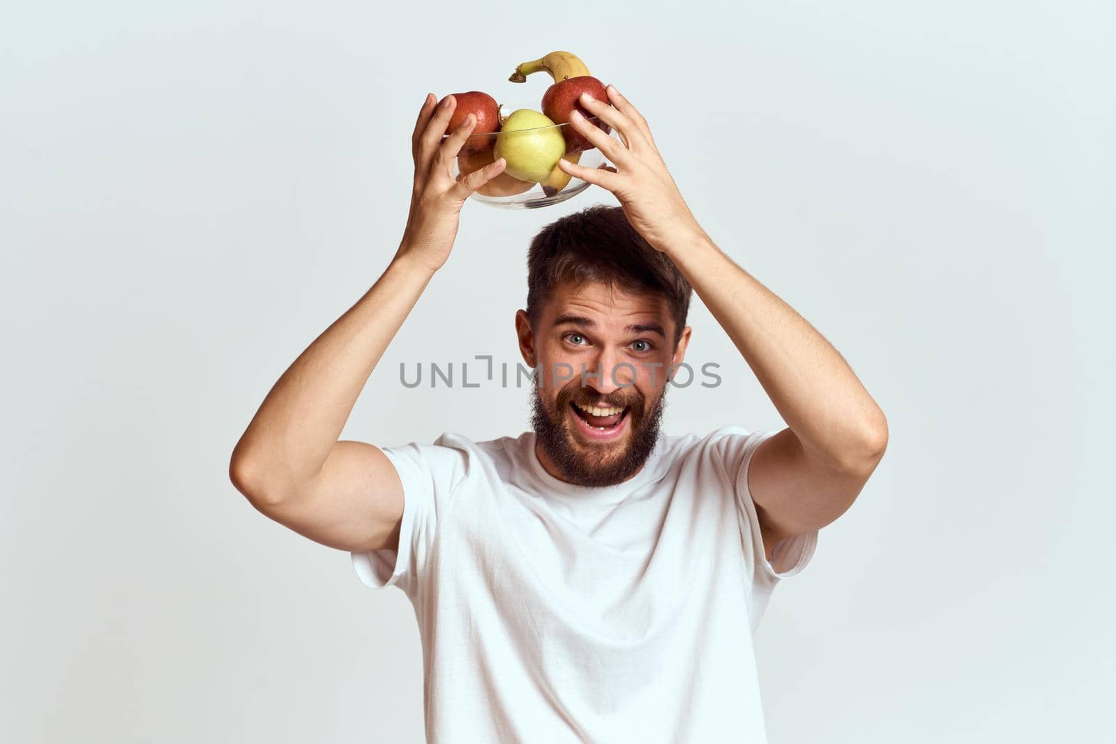A man in a white t-shirt vitamins fruit diet vegetarian. High quality photo
