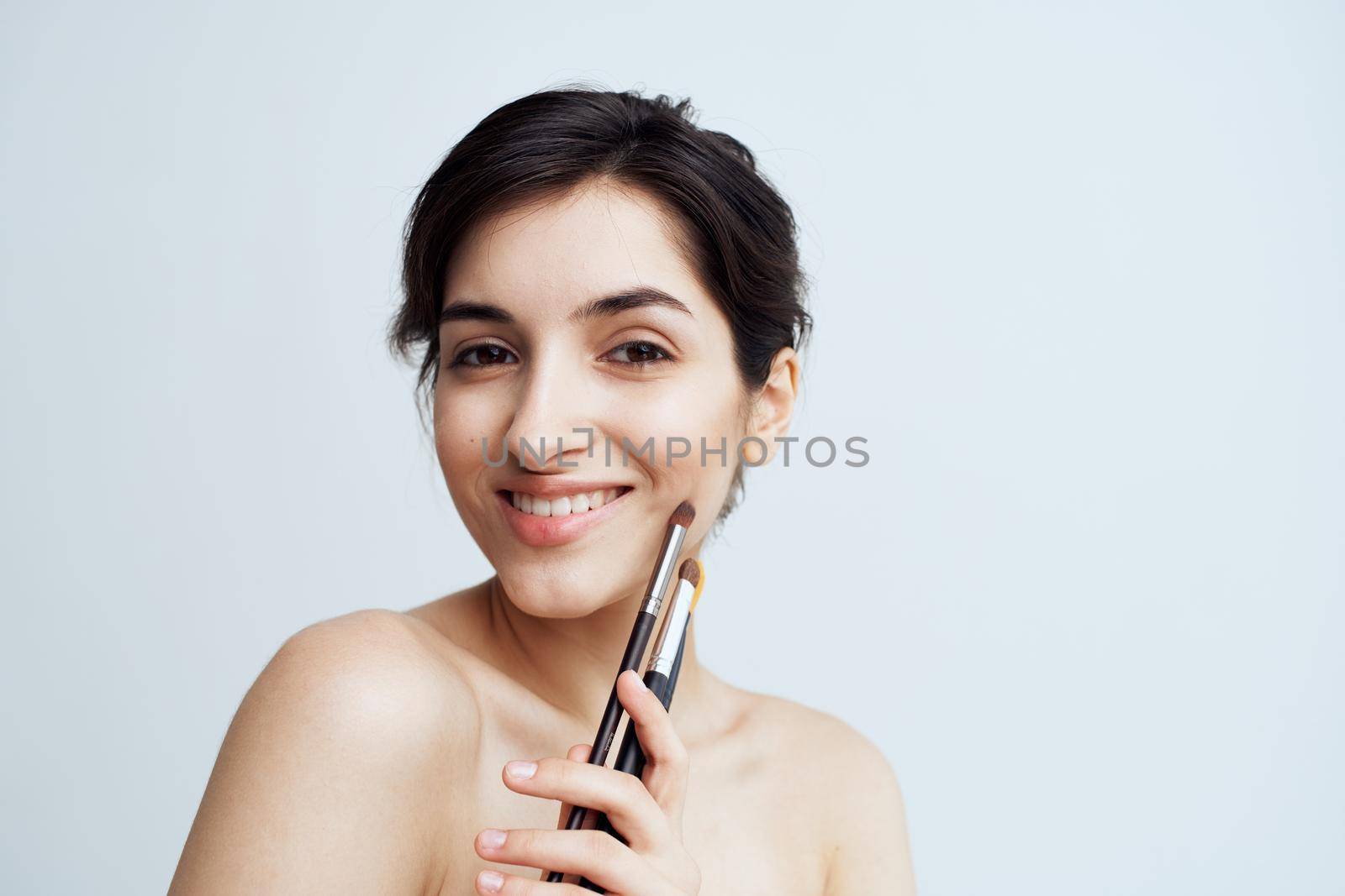 Pretty woman nude shoulders makeup brush cosmetics skin care. High quality photo