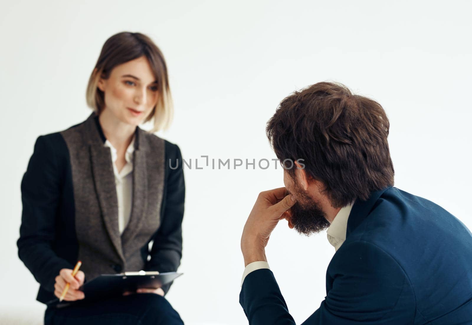 Woman and man in a jacket on a light background job interview. High quality photo