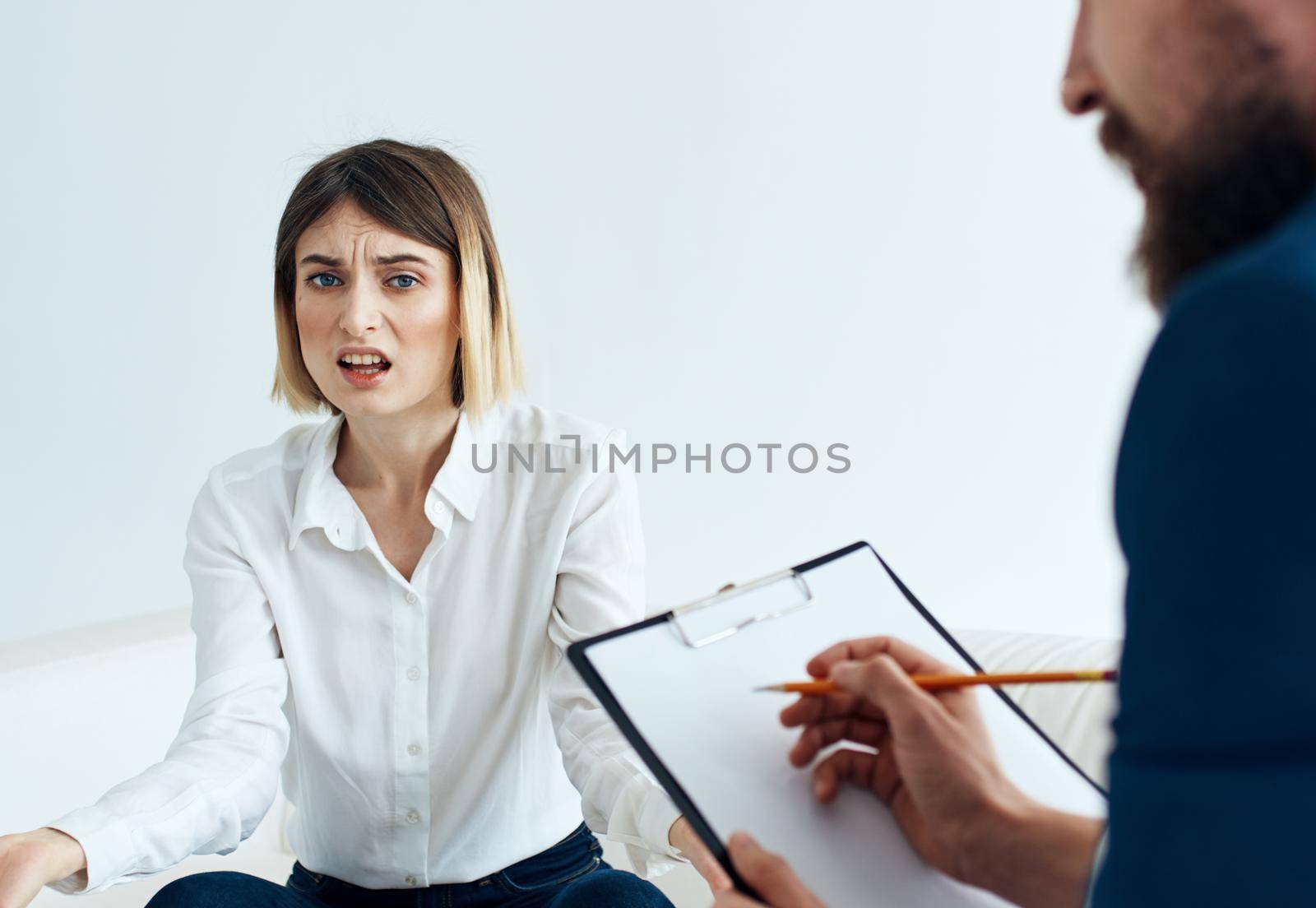 A woman on the sofa of a psychologist at the reception and a man with documents. High quality photo