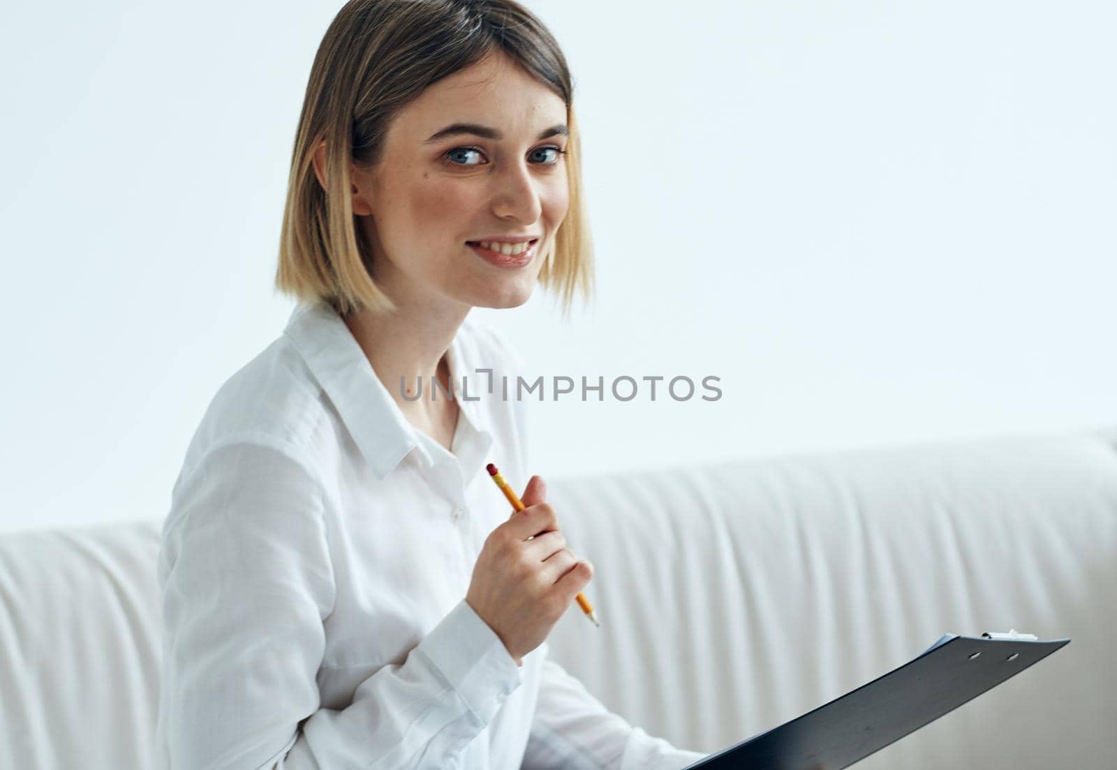 female psychologist with a folder of documents sits on the couch in a bright room. High quality photo