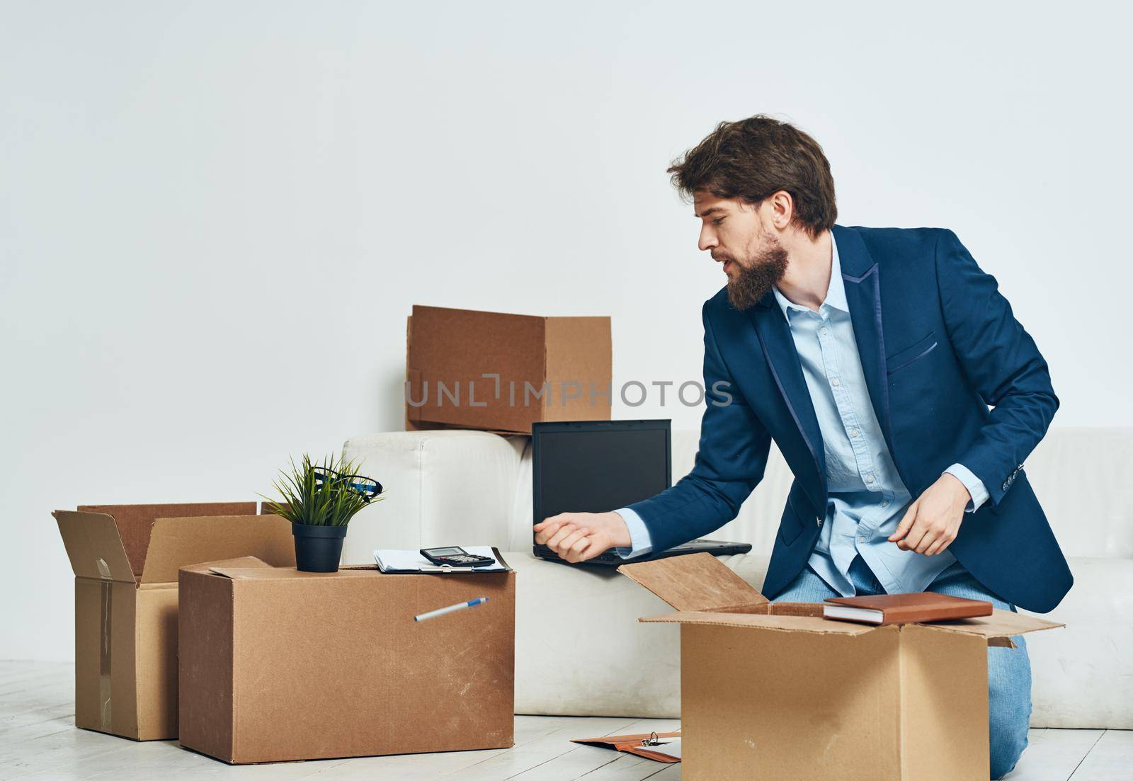 A man sits boxes with things unpacking a new professional job. High quality photo