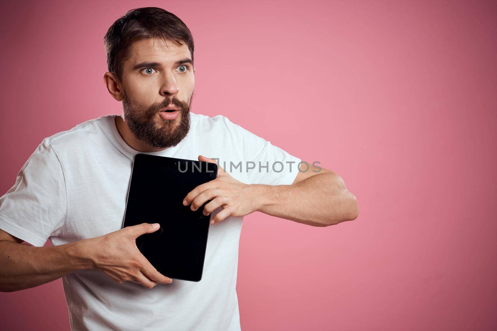 man in white t-shirt tablet technology communication professional pink background. High quality photo