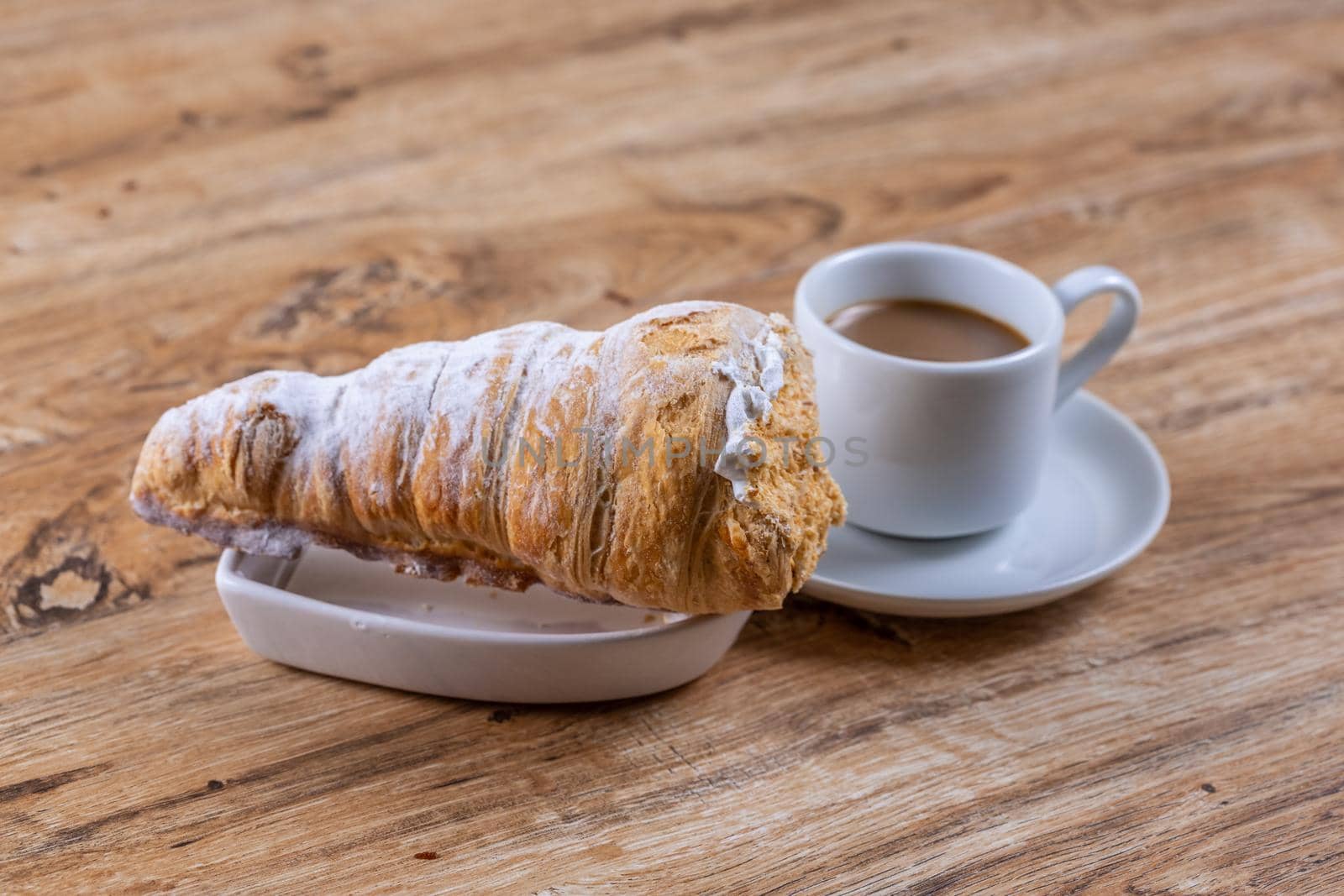  A cup of coffee next to delicious aromatic puff pastry cone with protein cream by galinasharapova