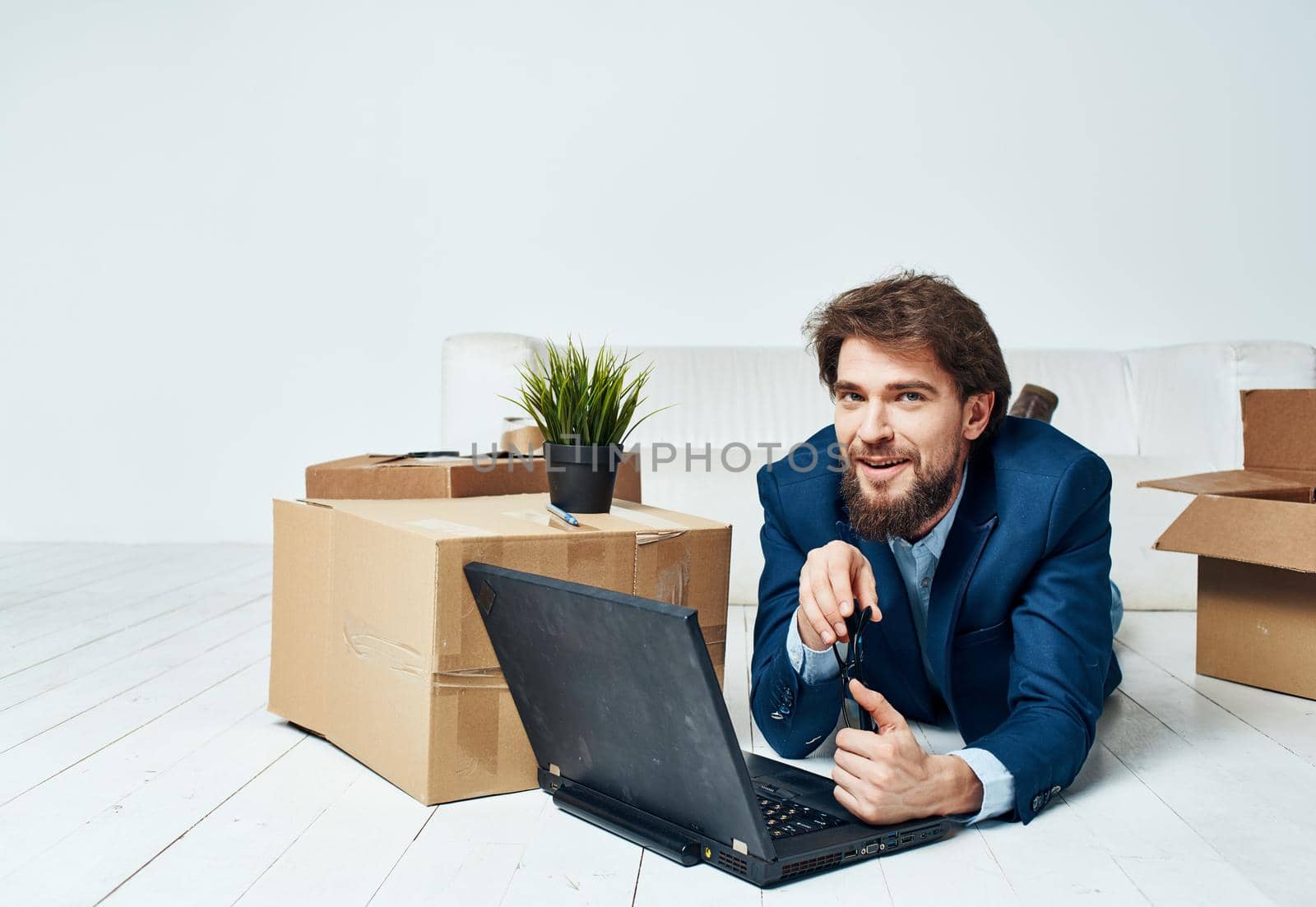 A man lies in front of a laptop boxes with things unpacking Office professional businessman. High quality photo