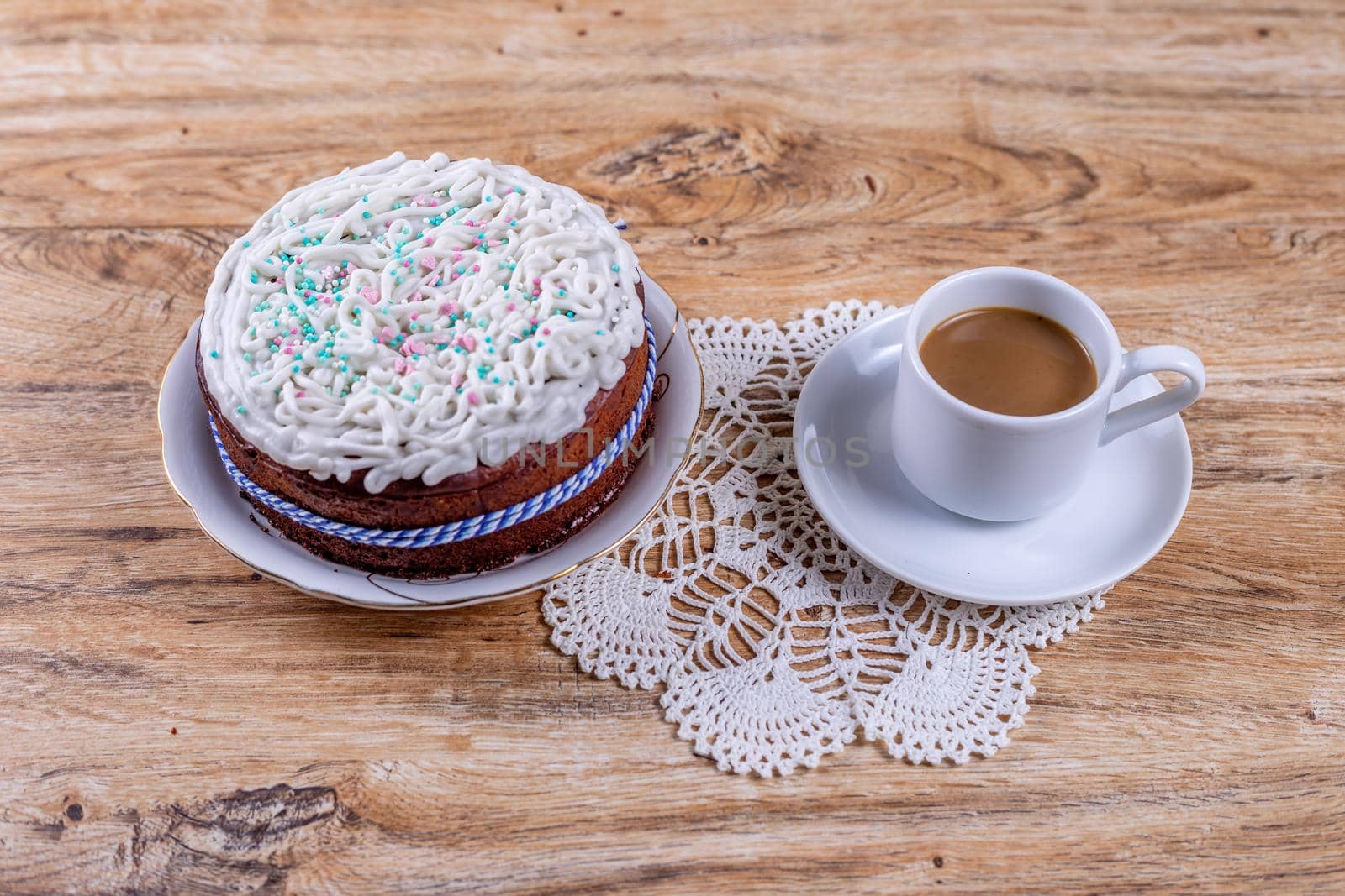 Homemade cake, decorated with white icing with decorative sprinkles and coffee by galinasharapova