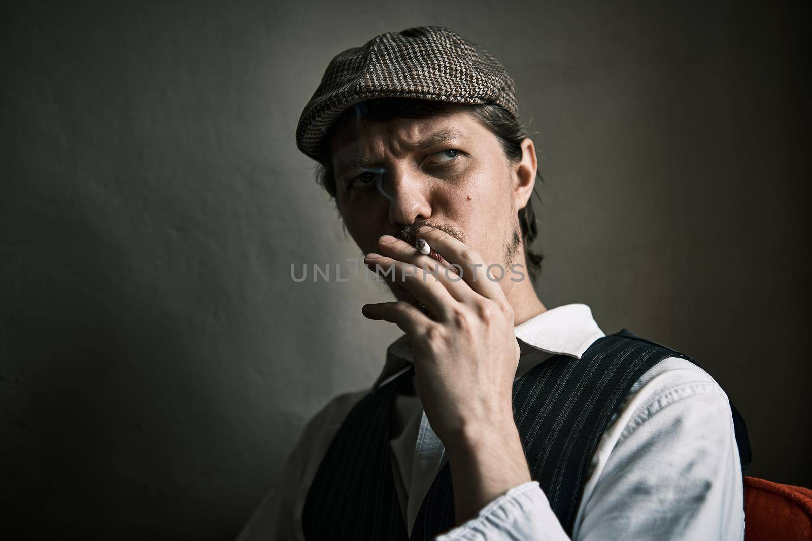 Young guy smoke a cigarette, dressed in a retro style by snep_photo