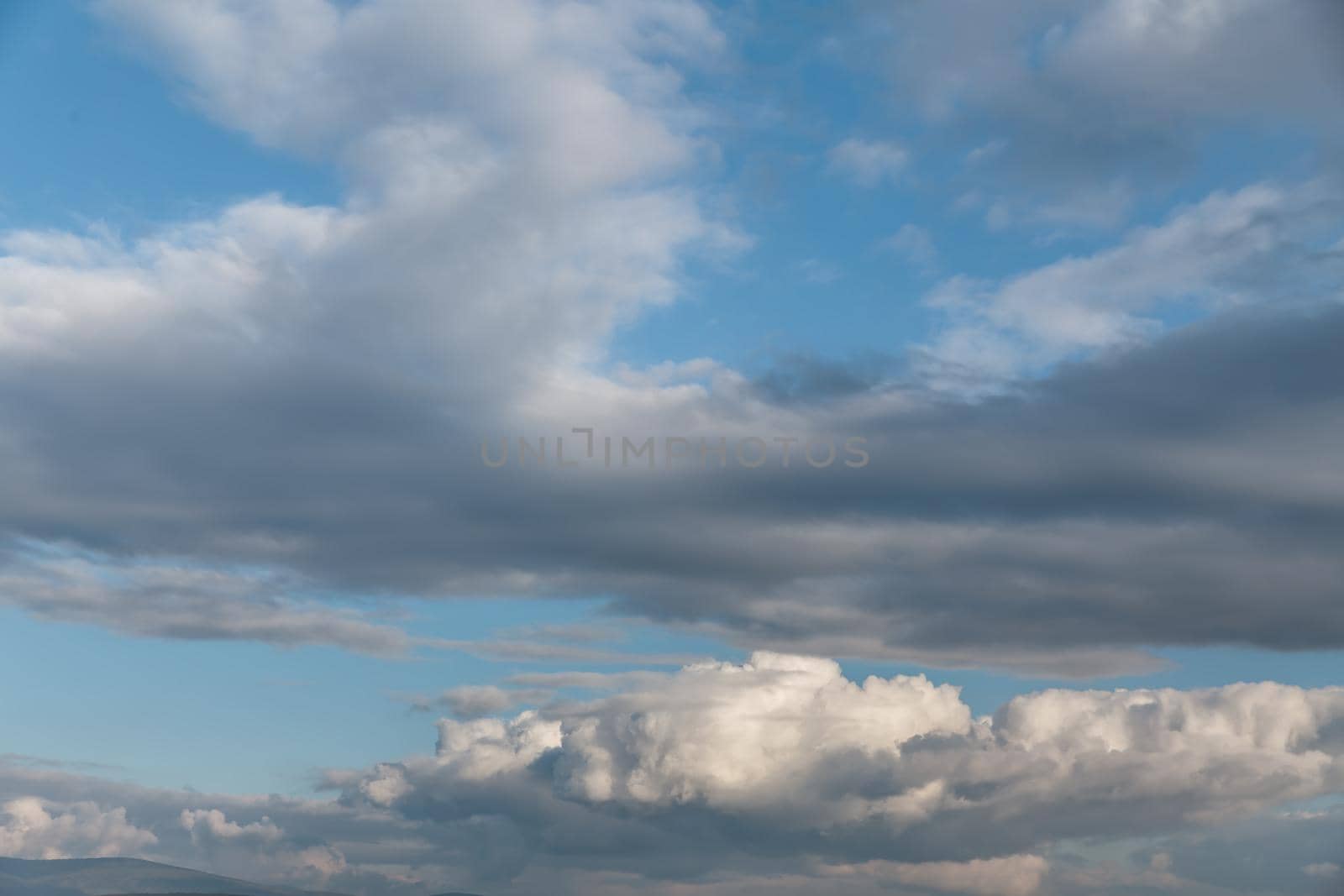 Nature background. White cumulus clouds on the blue sky