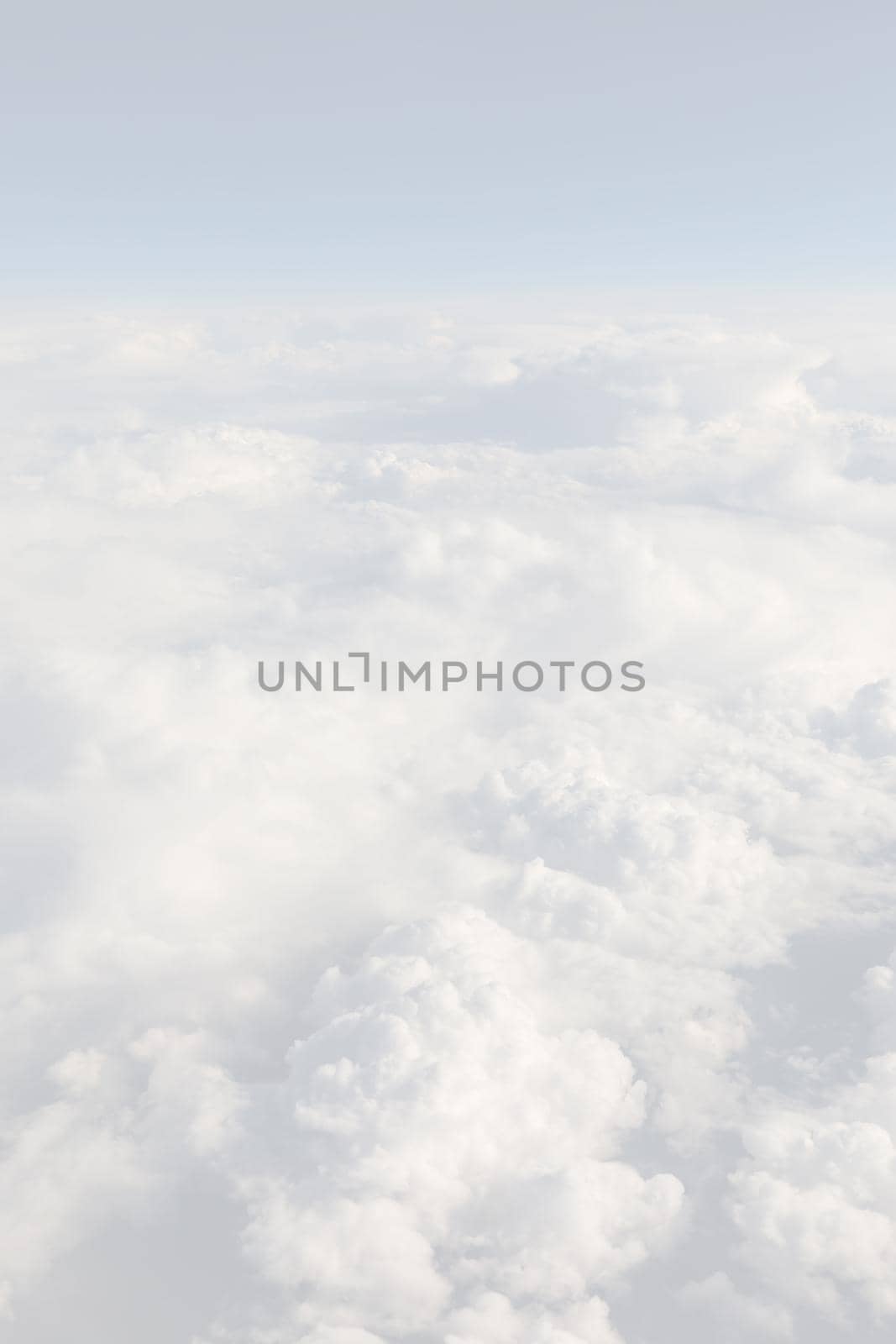 Sky with clouds, a view from an aeroplane above the clouds. Abstract nature background with clouds in light tonality. White cumulus clouds