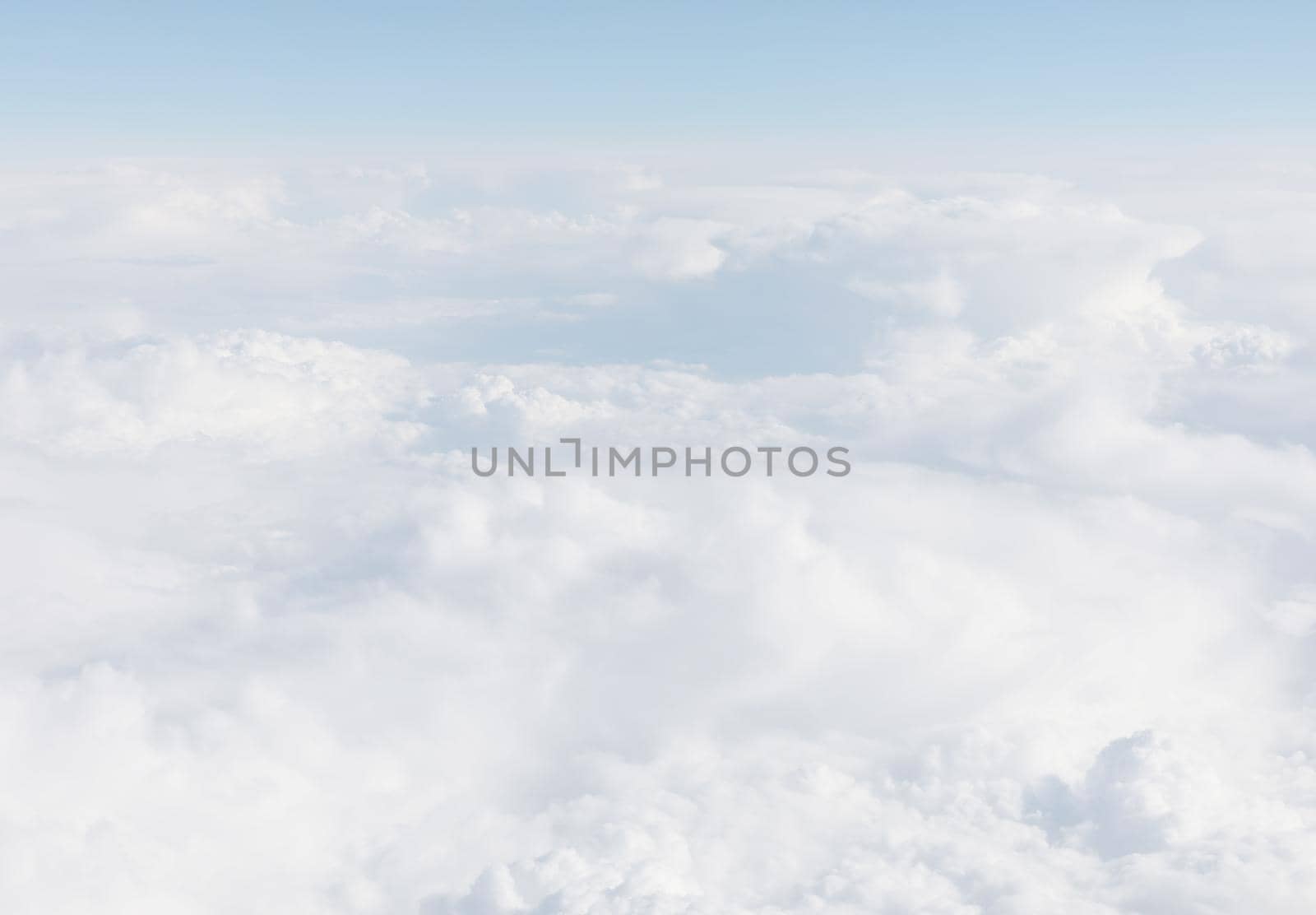 Sky with clouds, a view from an aeroplane above the clouds. Abstract nature background with clouds in light tonality. White cumulus clouds
