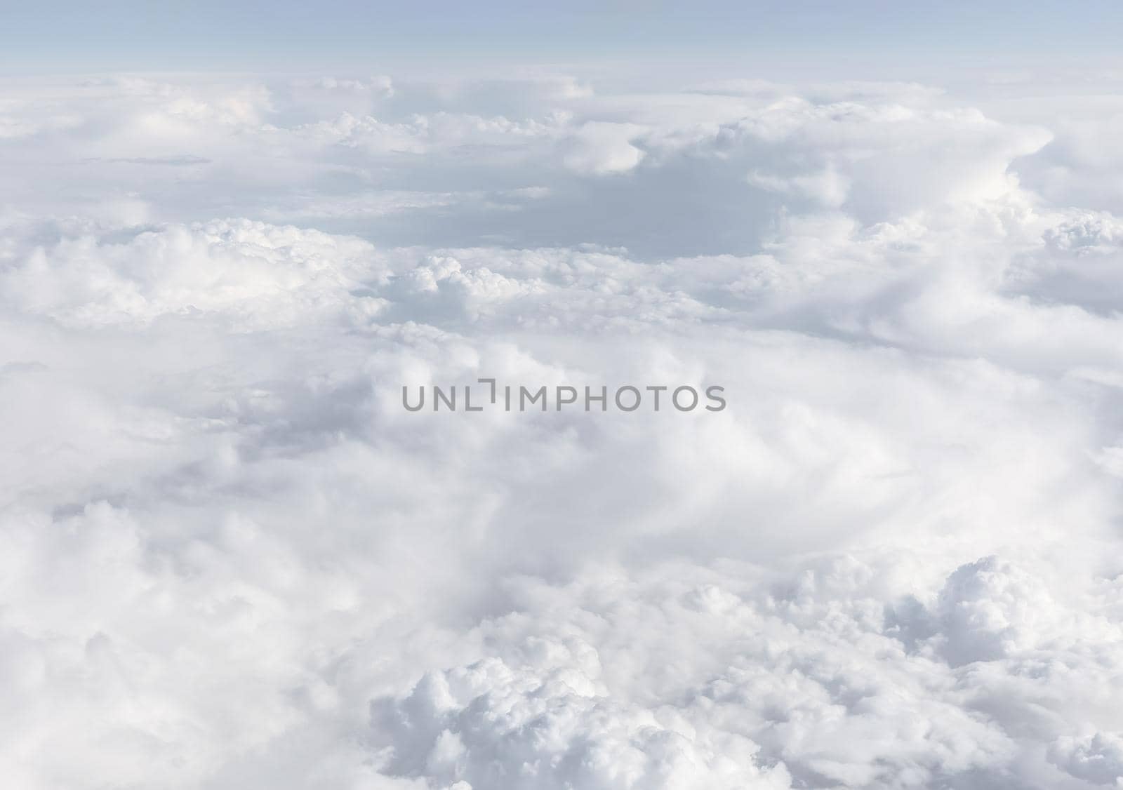 Sky with clouds, a view from an aeroplane above the clouds. Abstract nature background with clouds in light tonality. White cumulus clouds