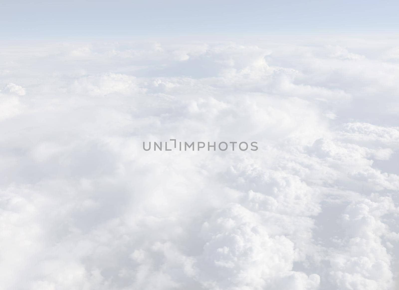 Sky with clouds, a view from an aeroplane above the clouds. Abstract nature background with clouds in light tonality. White cumulus clouds