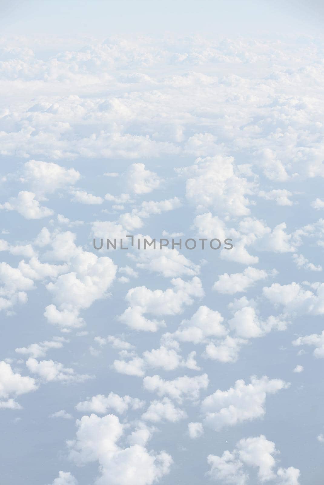 Sky with clouds, a view from an aeroplane above the clouds. Abstract nature background with clouds in light tonality. White cumulus clouds