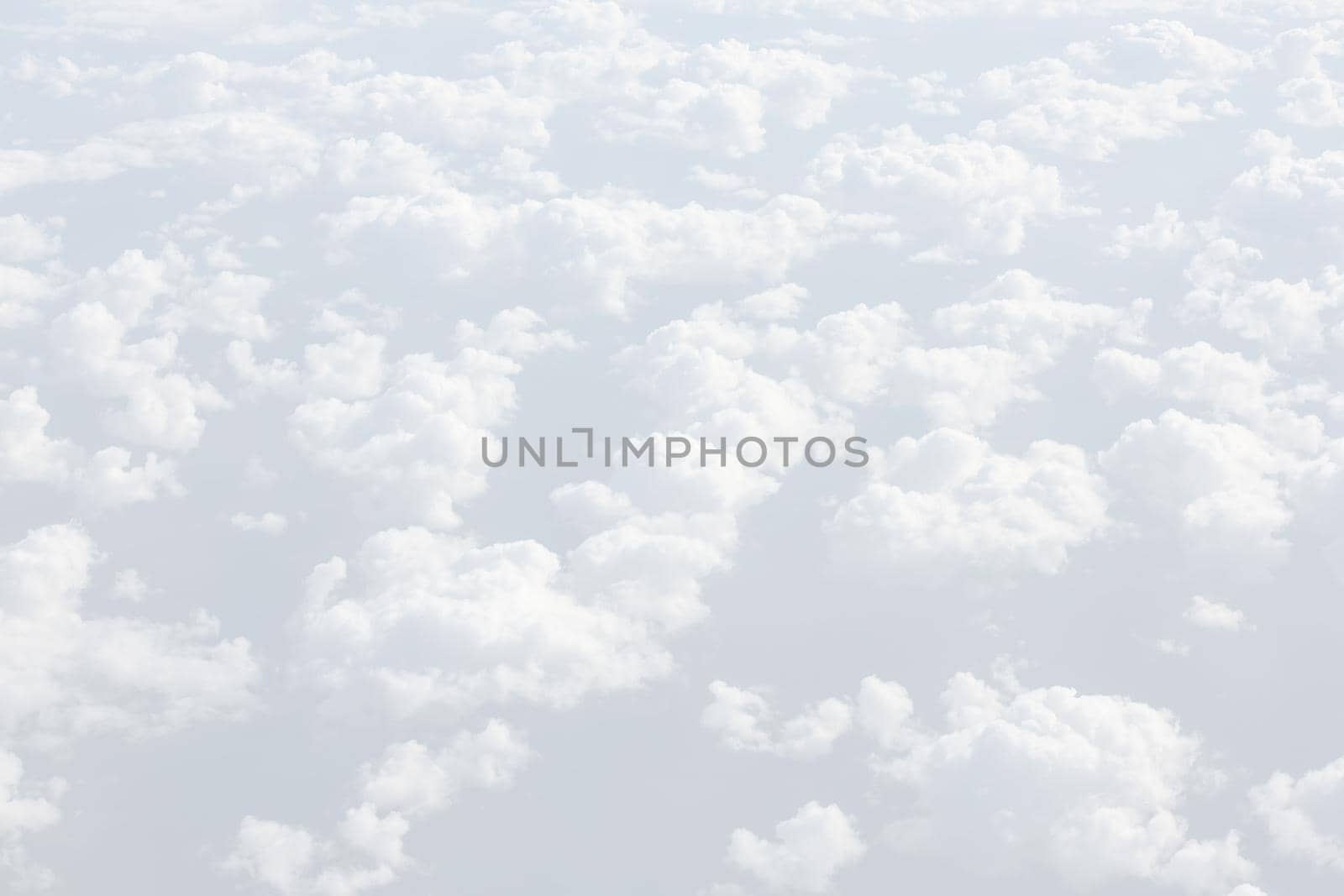 Sky with clouds, a view from an aeroplane above the clouds. Abstract nature background with clouds in light tonality. White cumulus clouds