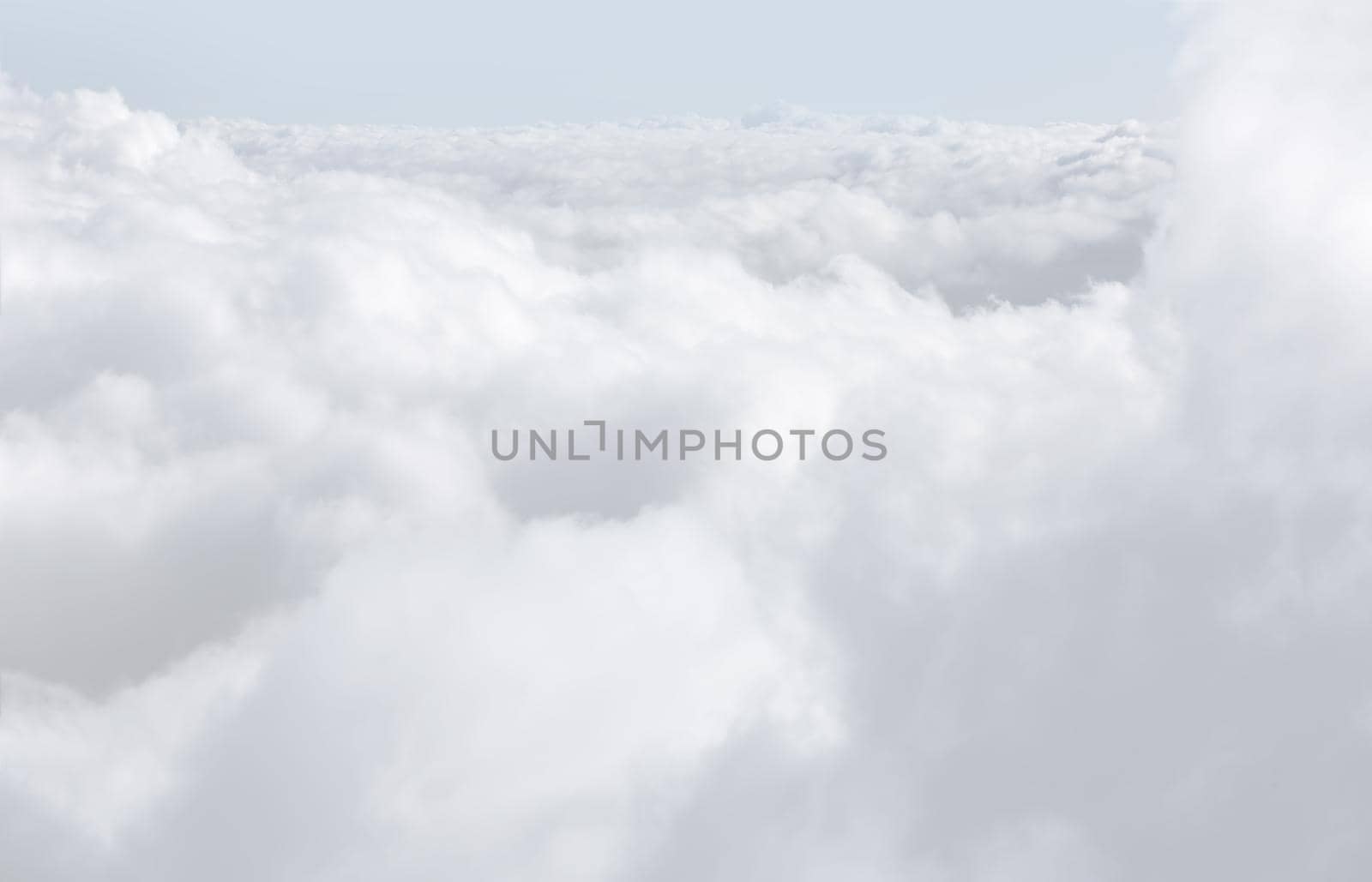 Sky with clouds, a view from an aeroplane above the clouds. Abstract nature background with clouds in light tonality. White cumulus clouds