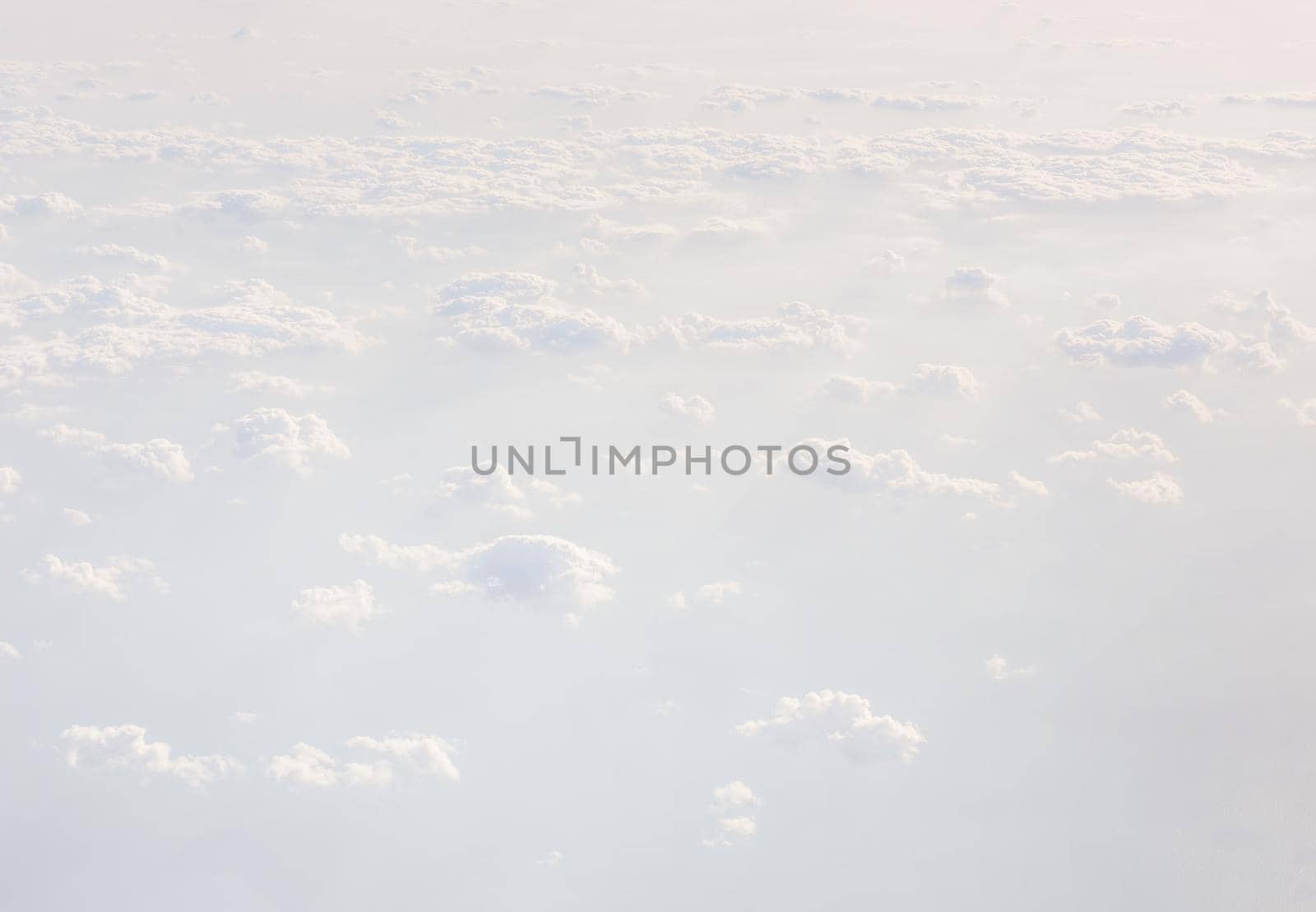 Sky with clouds, a view from an aeroplane above the clouds. Abstract nature background with clouds in light tonality. White cumulus clouds