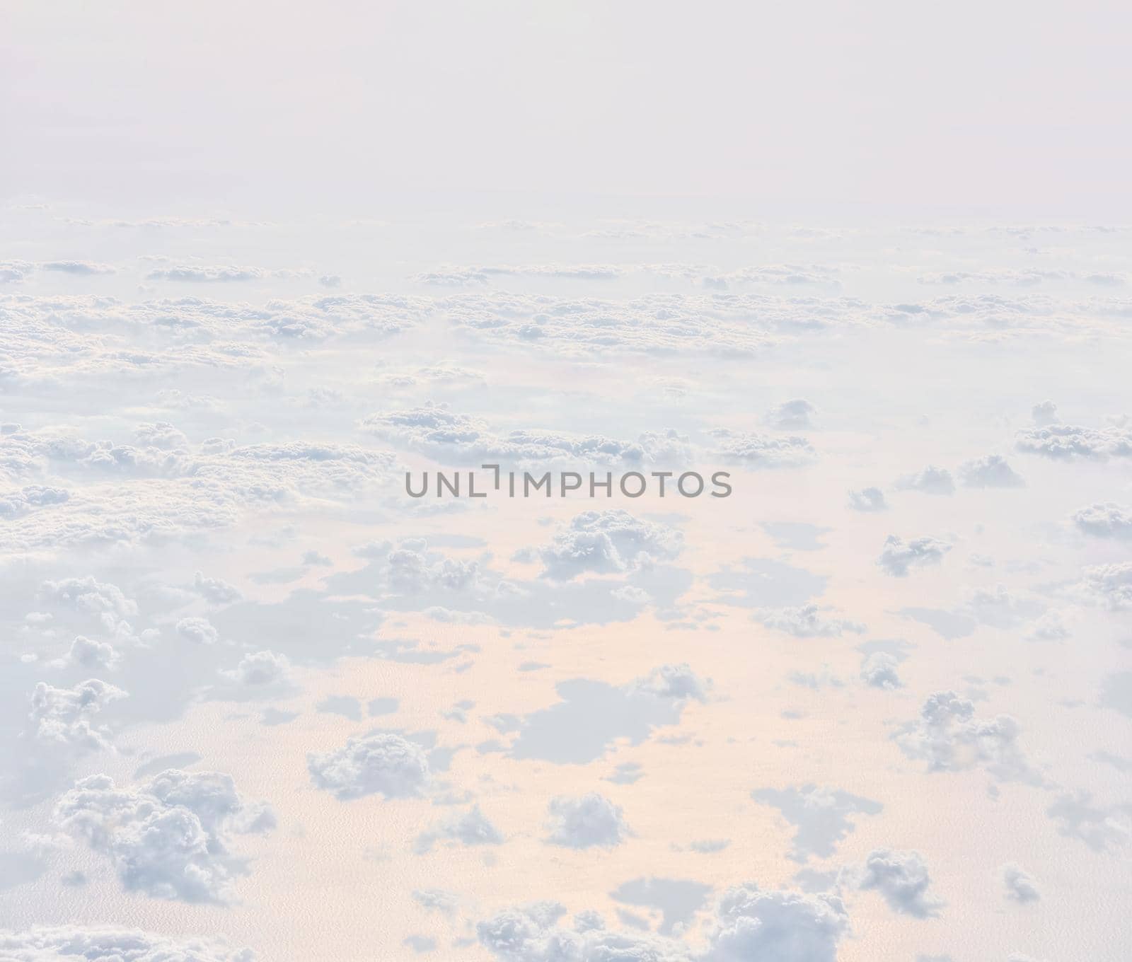 Sky with clouds, a view from an aeroplane above the clouds. Abstract nature background with clouds in light tonality. White cumulus clouds