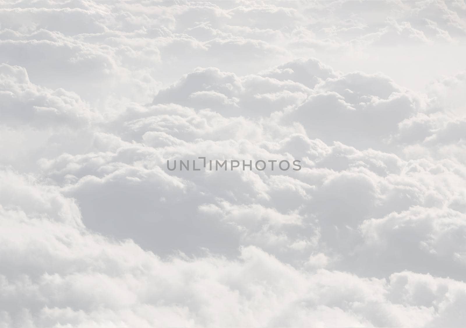 Sky with clouds, a view from an aeroplane above the clouds. Abstract nature background with clouds in light tonality. White cumulus clouds
