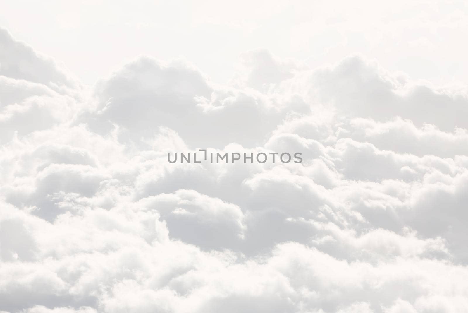 Sky with clouds, a view from an aeroplane above the clouds. Abstract nature background with clouds in light tonality. White cumulus clouds