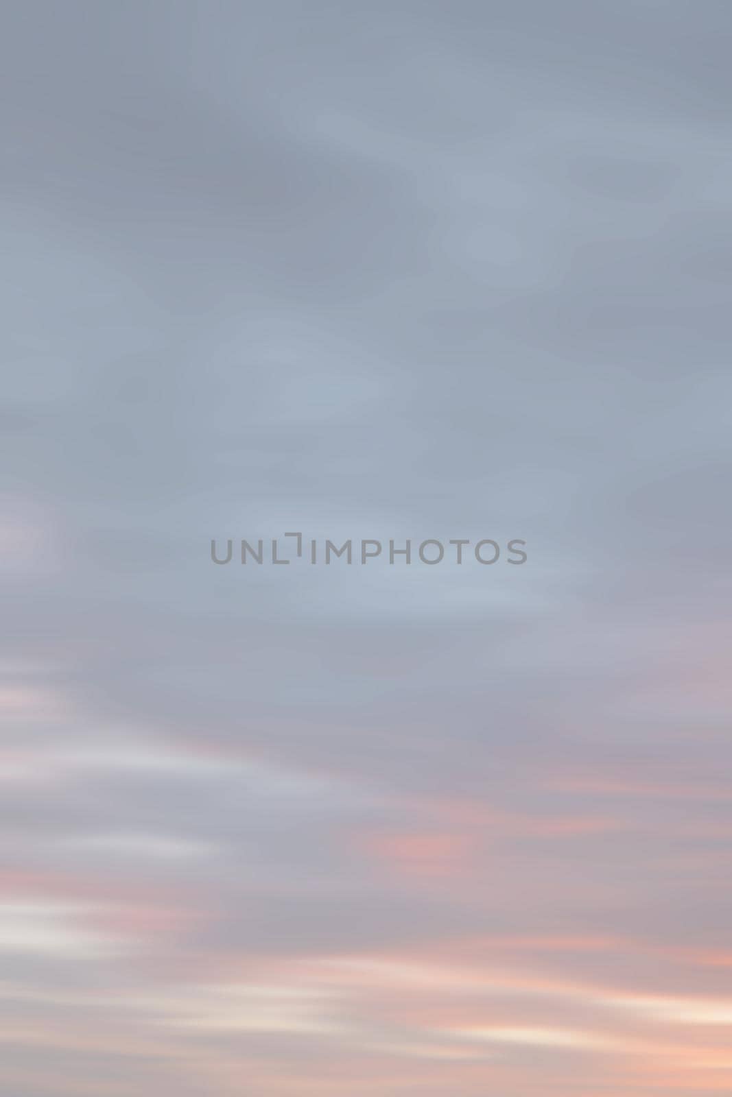 Blurry shot of the sunset sky. Abstract nature background with clouds in light tonality. 