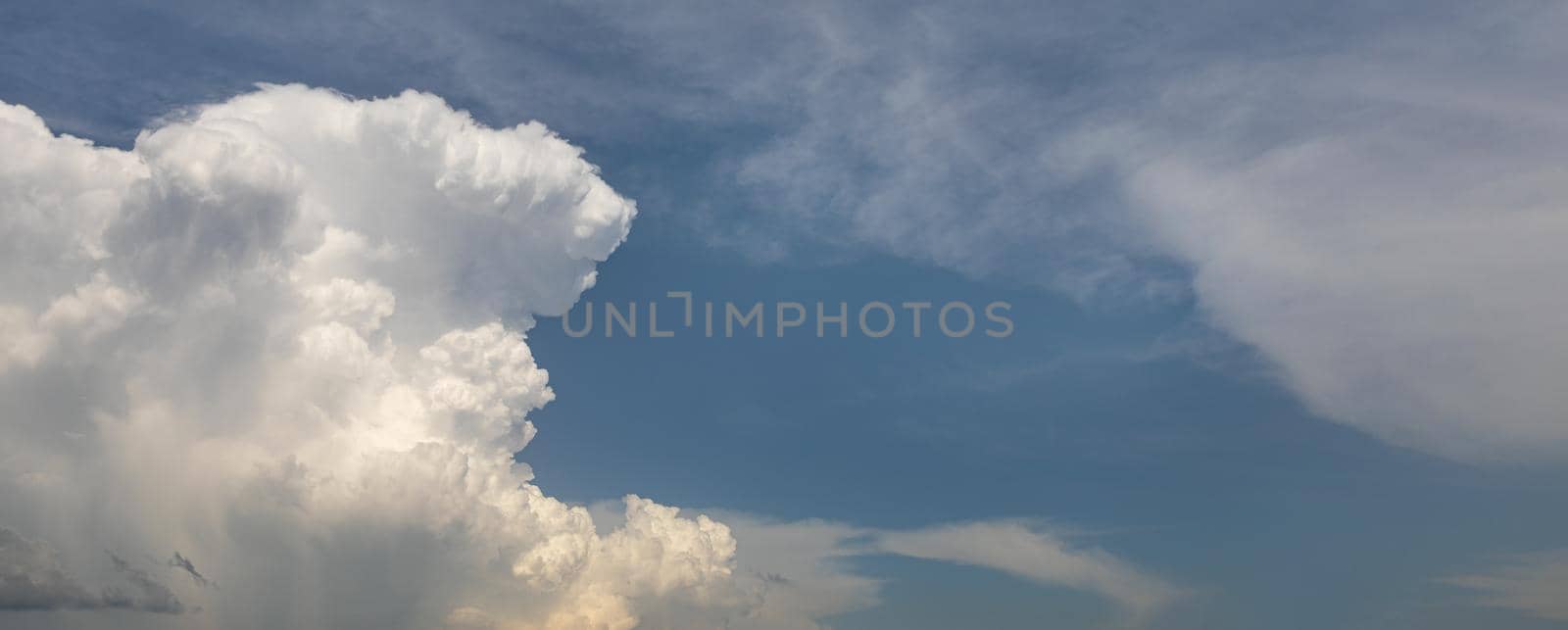 Natural background. Big and fluffy cumulonimbus cloud in the blue sky
