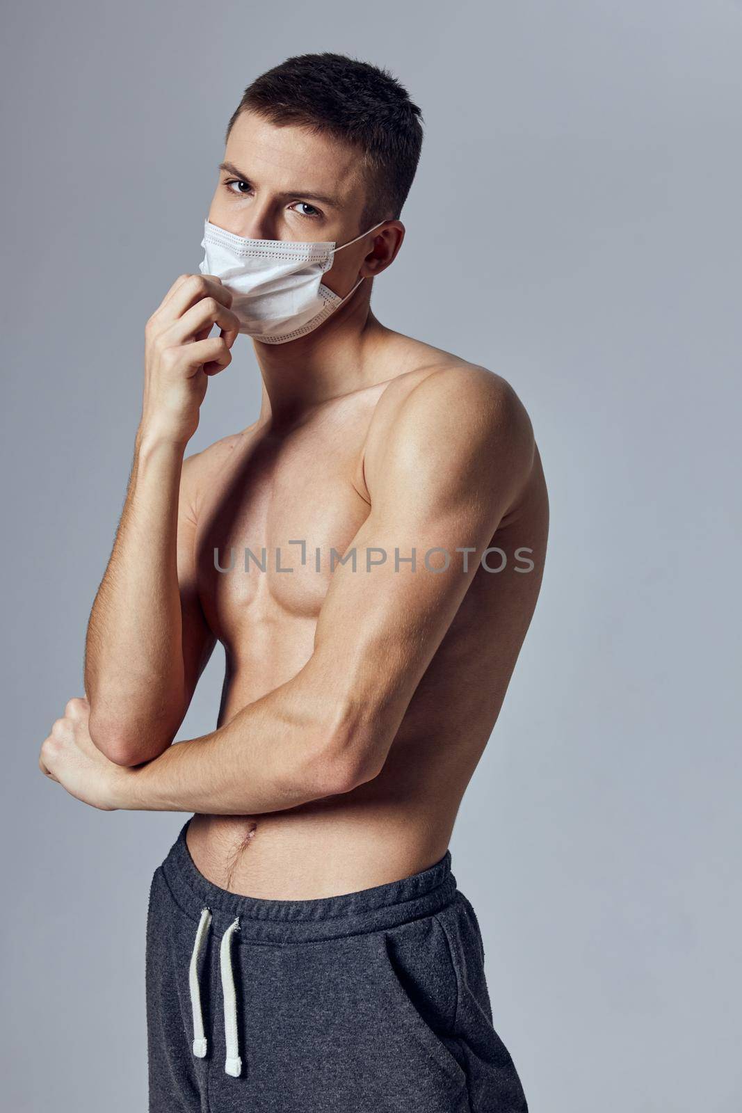 athletic man with muscular body medical mask black shorts . High quality photo