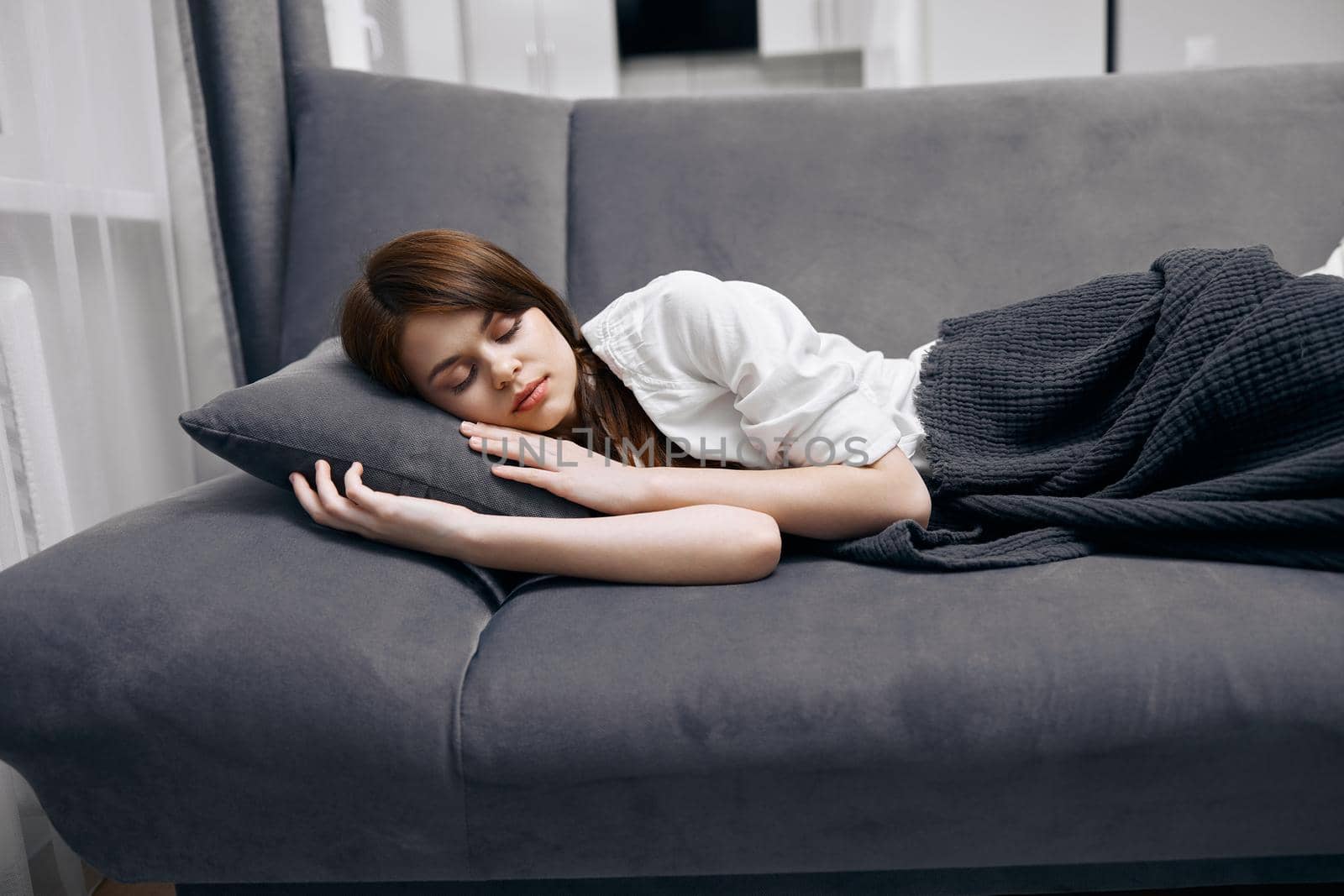woman with closed eyes lies on sofa with pillow at home. High quality photo