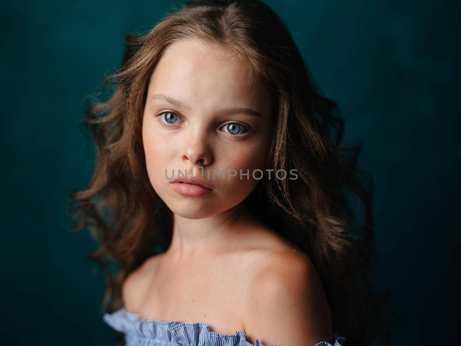 Portrait of a beautiful girl with curly hair hairstyle model bared shoulders. High quality photo