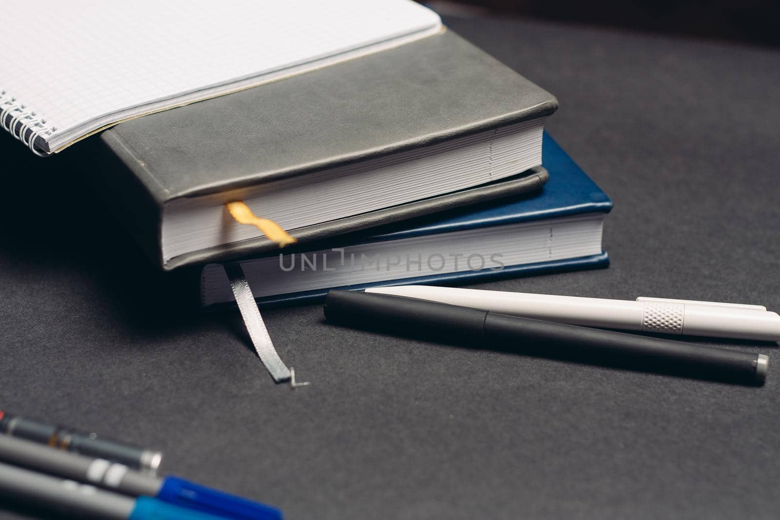 notebook books pens documents workplace office gray background. High quality photo