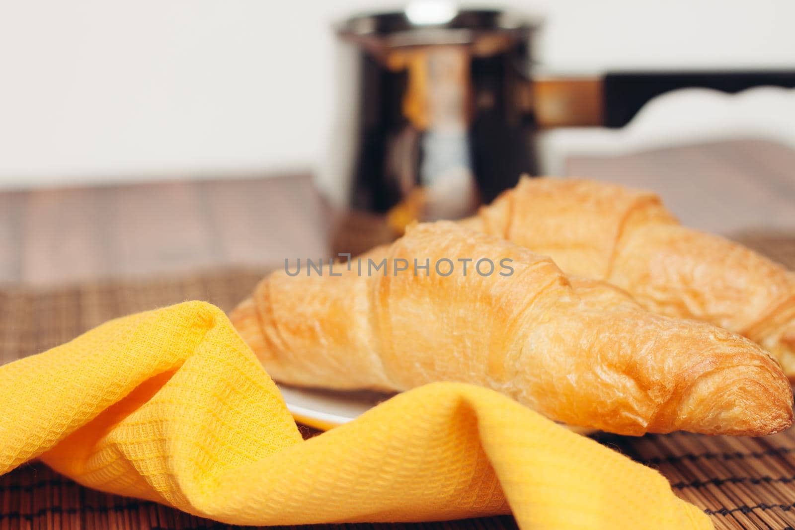 fresh croissants on a saucer table setting breakfast cup with drinks. High quality photo