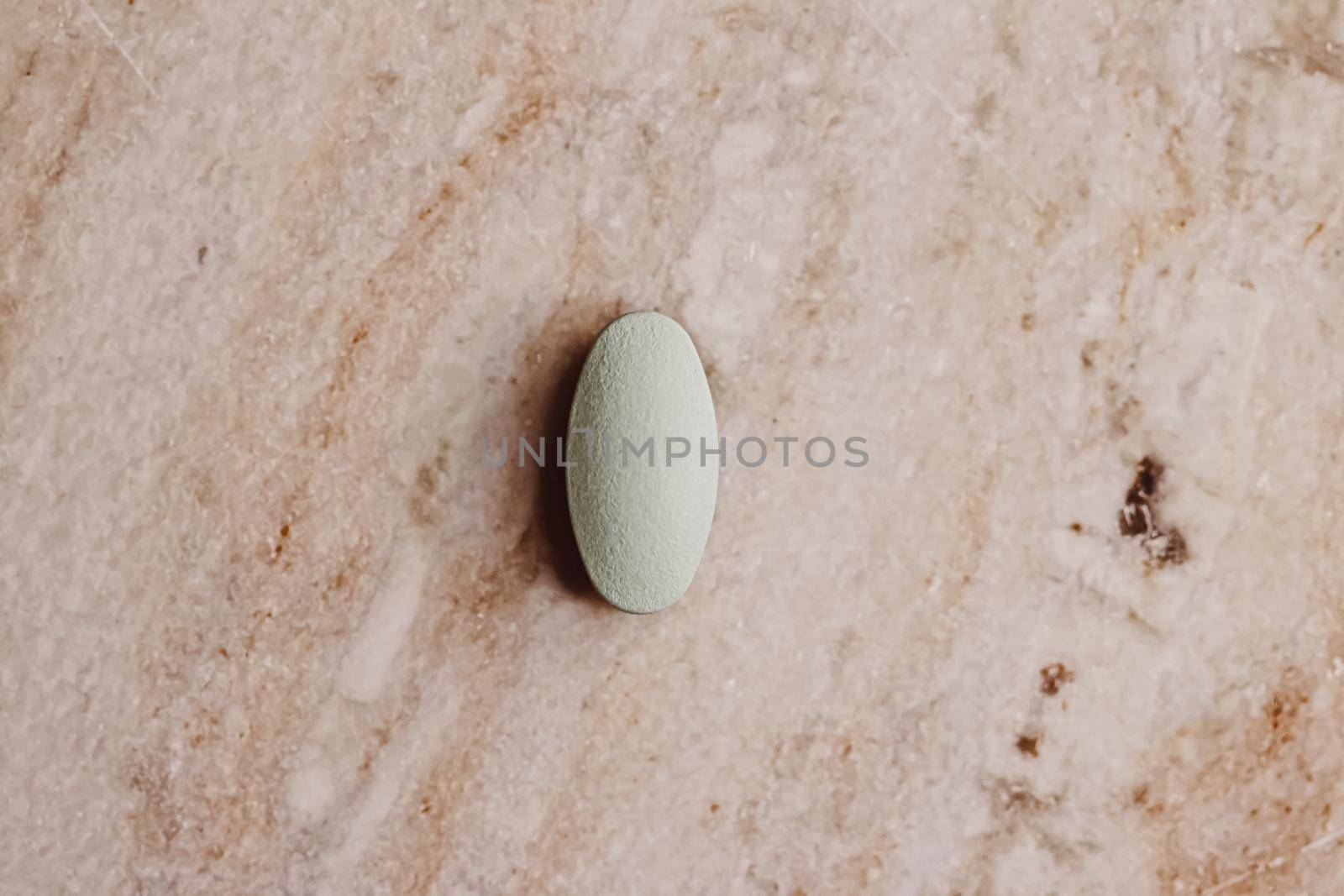 Medical pill on stone background, health and wellness closeup