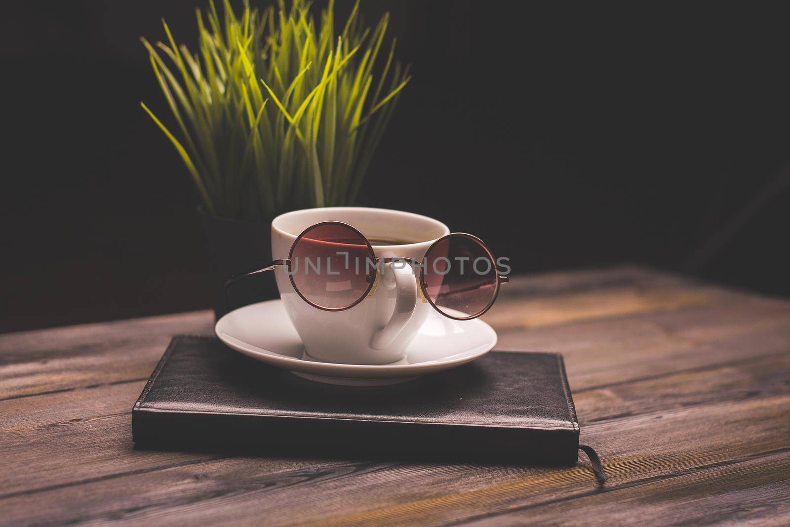 potted flower notepads pens stationery and coffee cup glasses wooden table. High quality photo