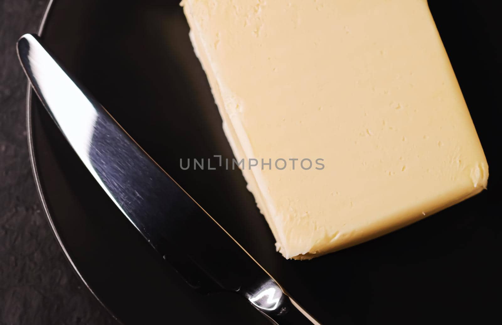 Sliced organic butter block and knife, breakfast food closeup