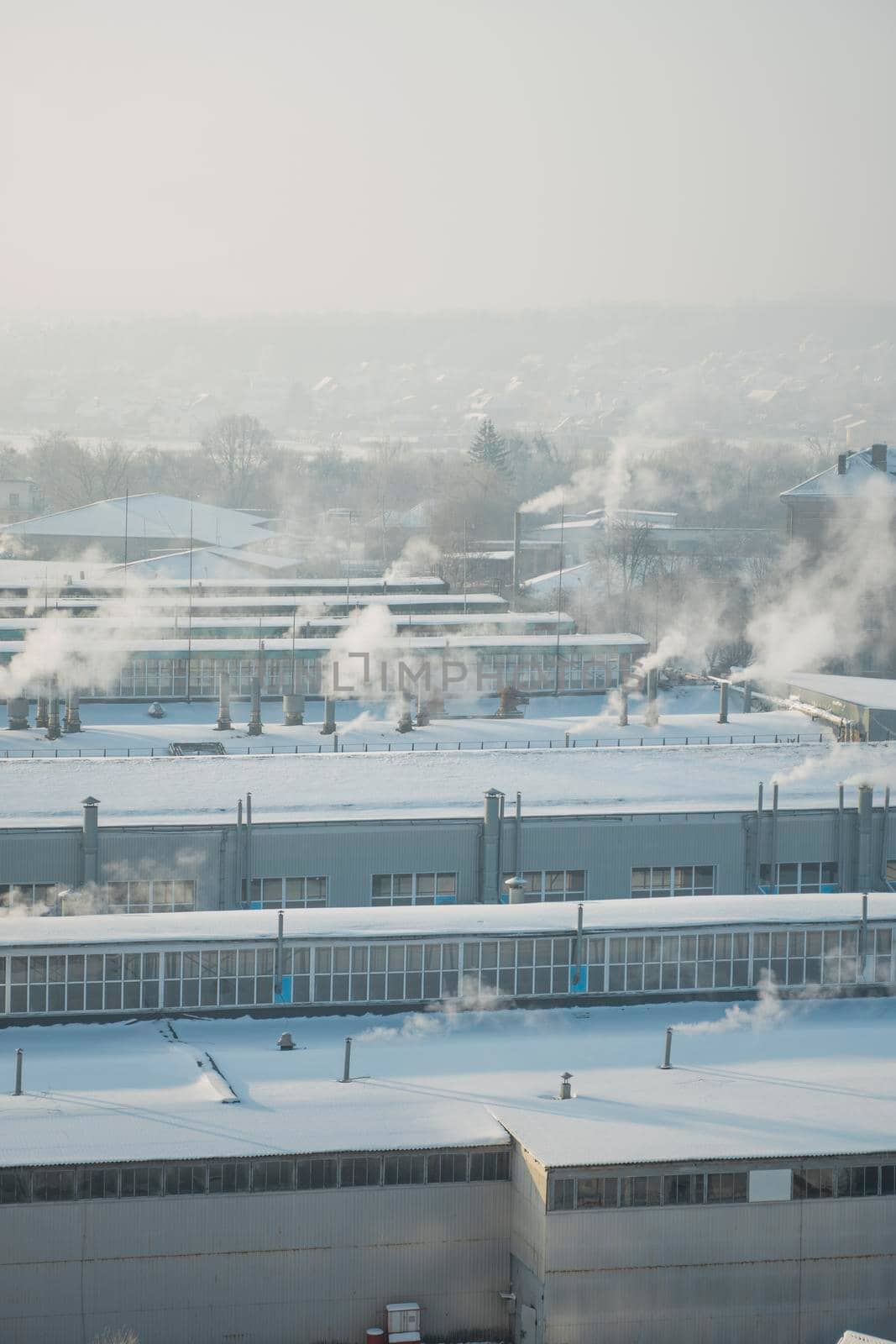 The factory chimneys are smoking during a winter season. The concept of air pollution. Environmental pollution by industrial waste