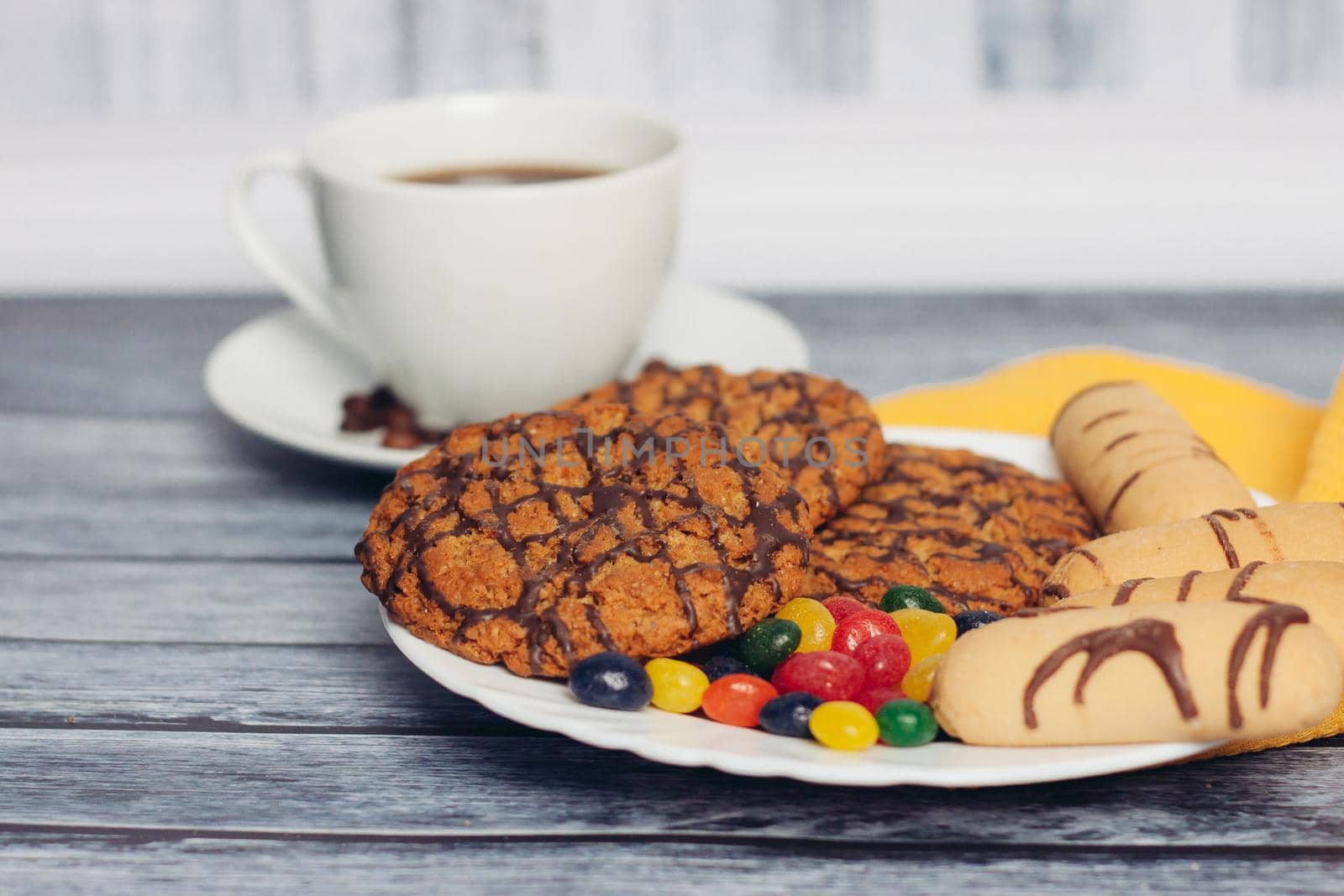 cookies on a plate a cup of tea on a wooden table a snack. High quality photo
