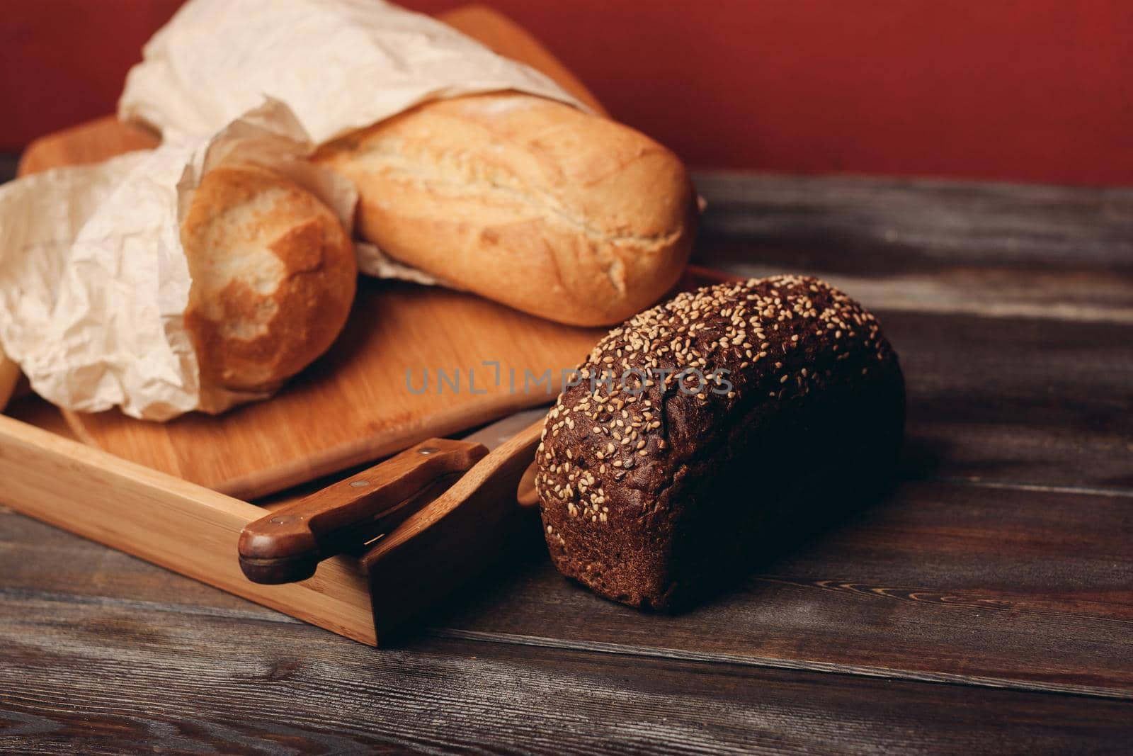 flour products rye bread on a tray and a sharp knife on the table. High quality photo
