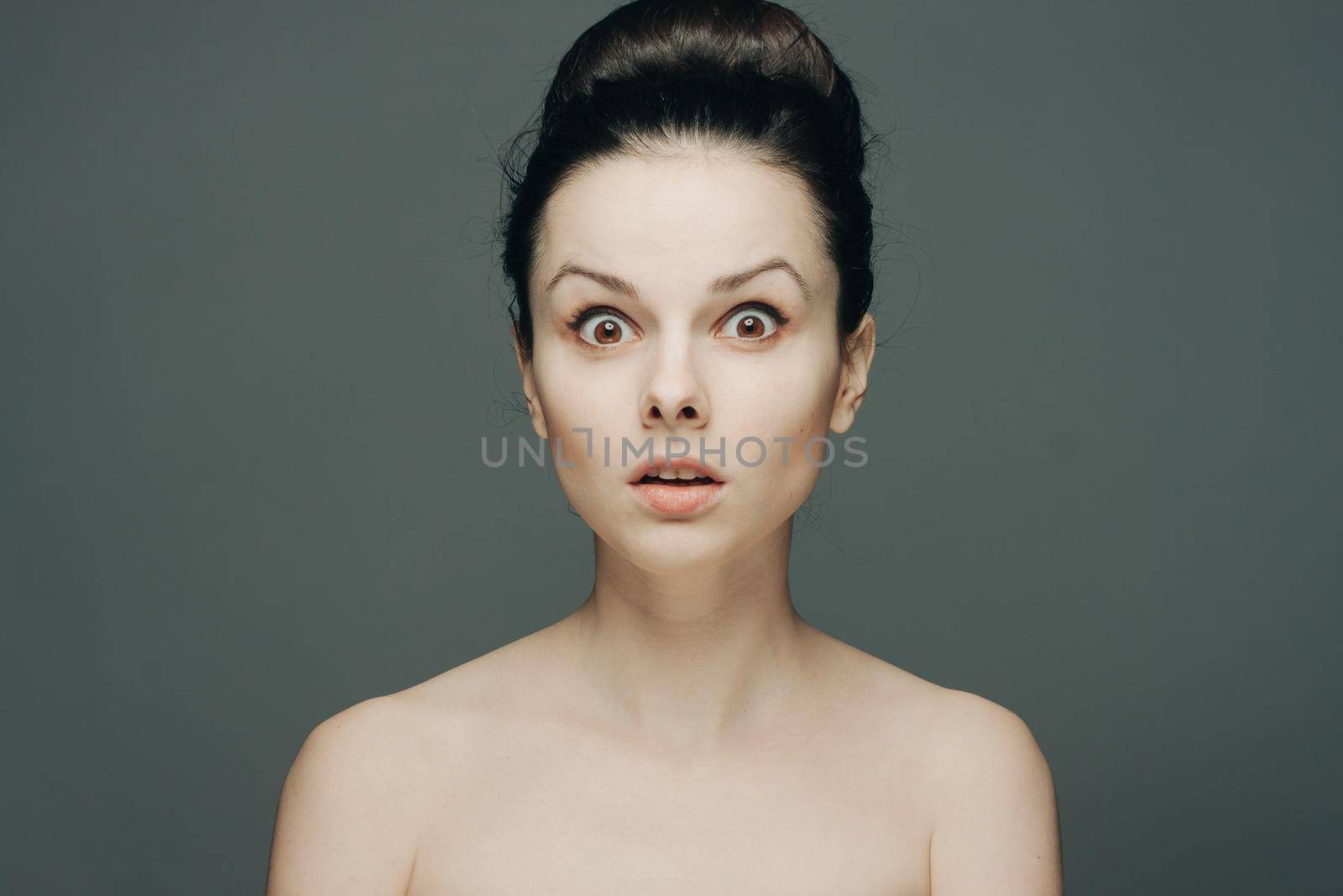 beautiful woman with bare shoulders clear skin collected hair emotions. High quality photo
