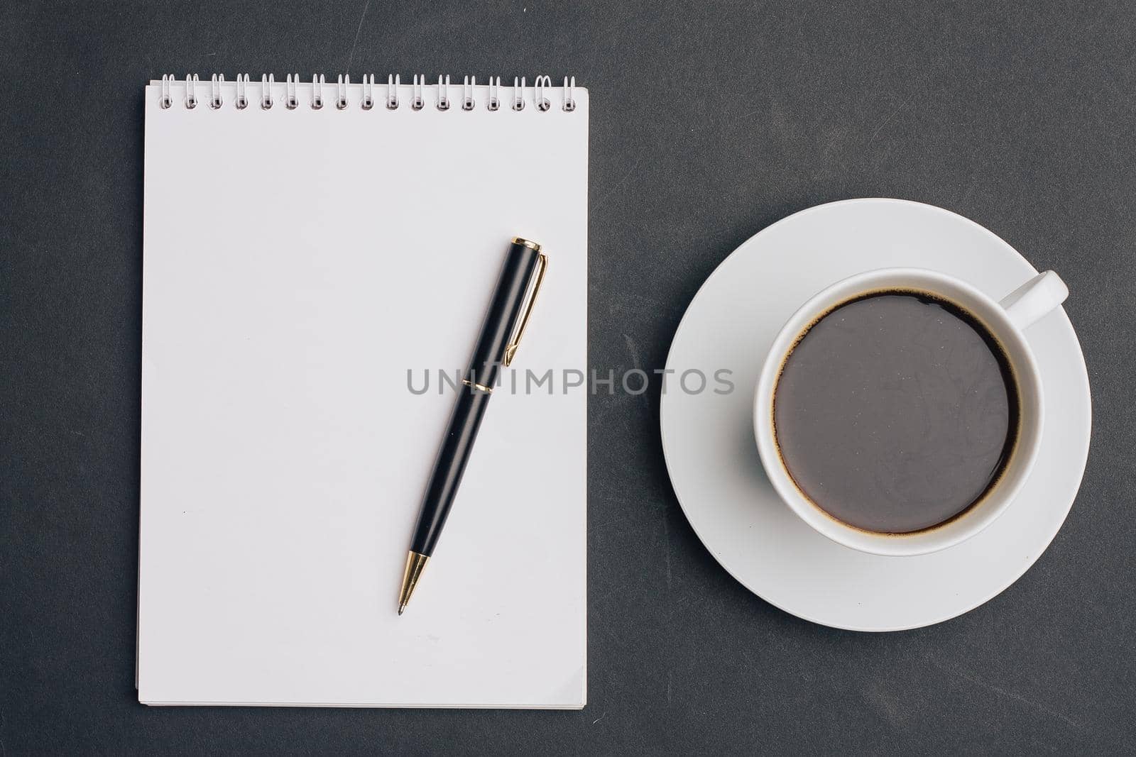 the dark background a Cup of coffee office Notepad handle the view from the top. High quality photo