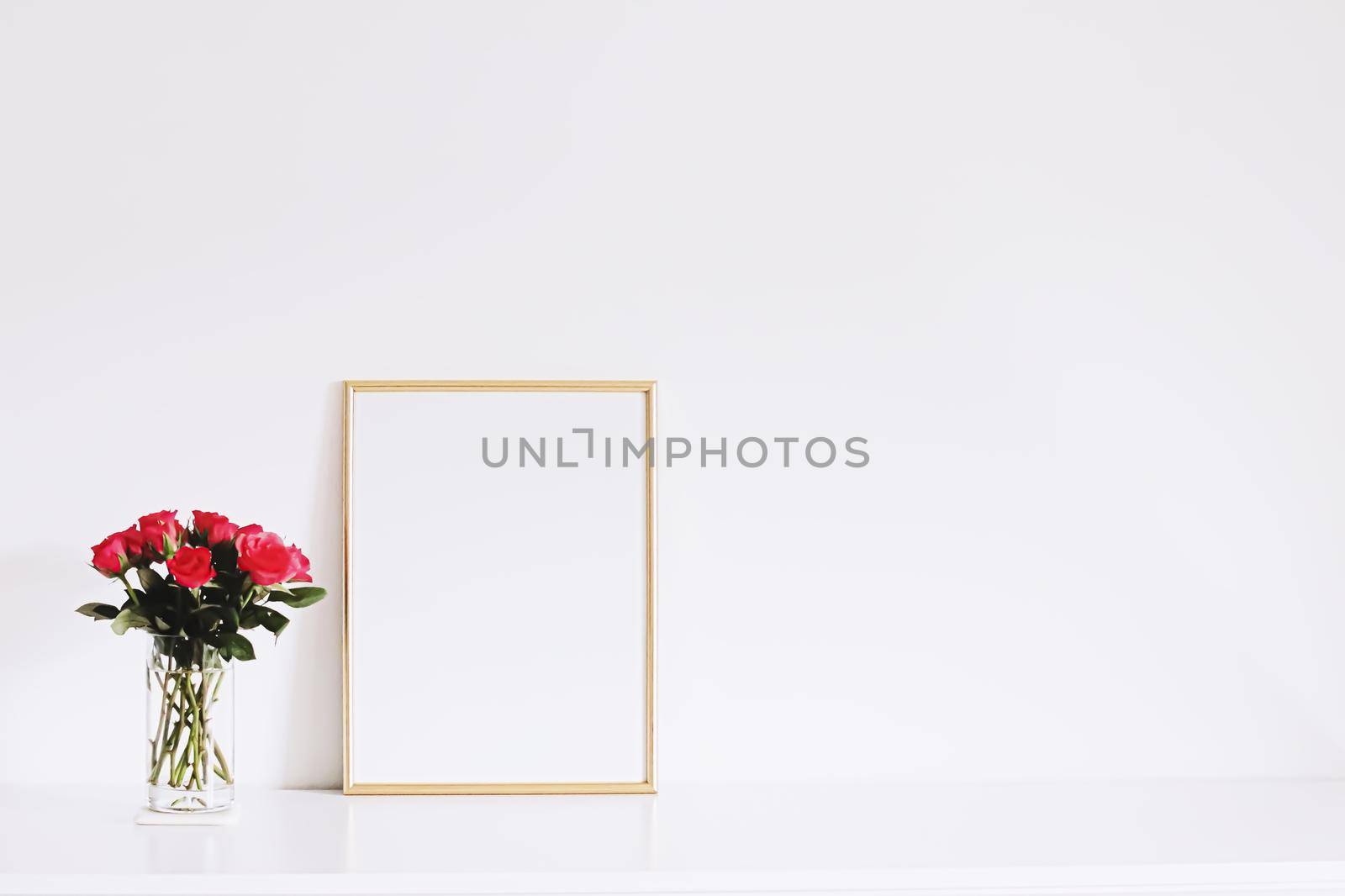 Golden horizontal frame and bouquet of rose flowers on white furniture, luxury home decor and design for mockup creations
