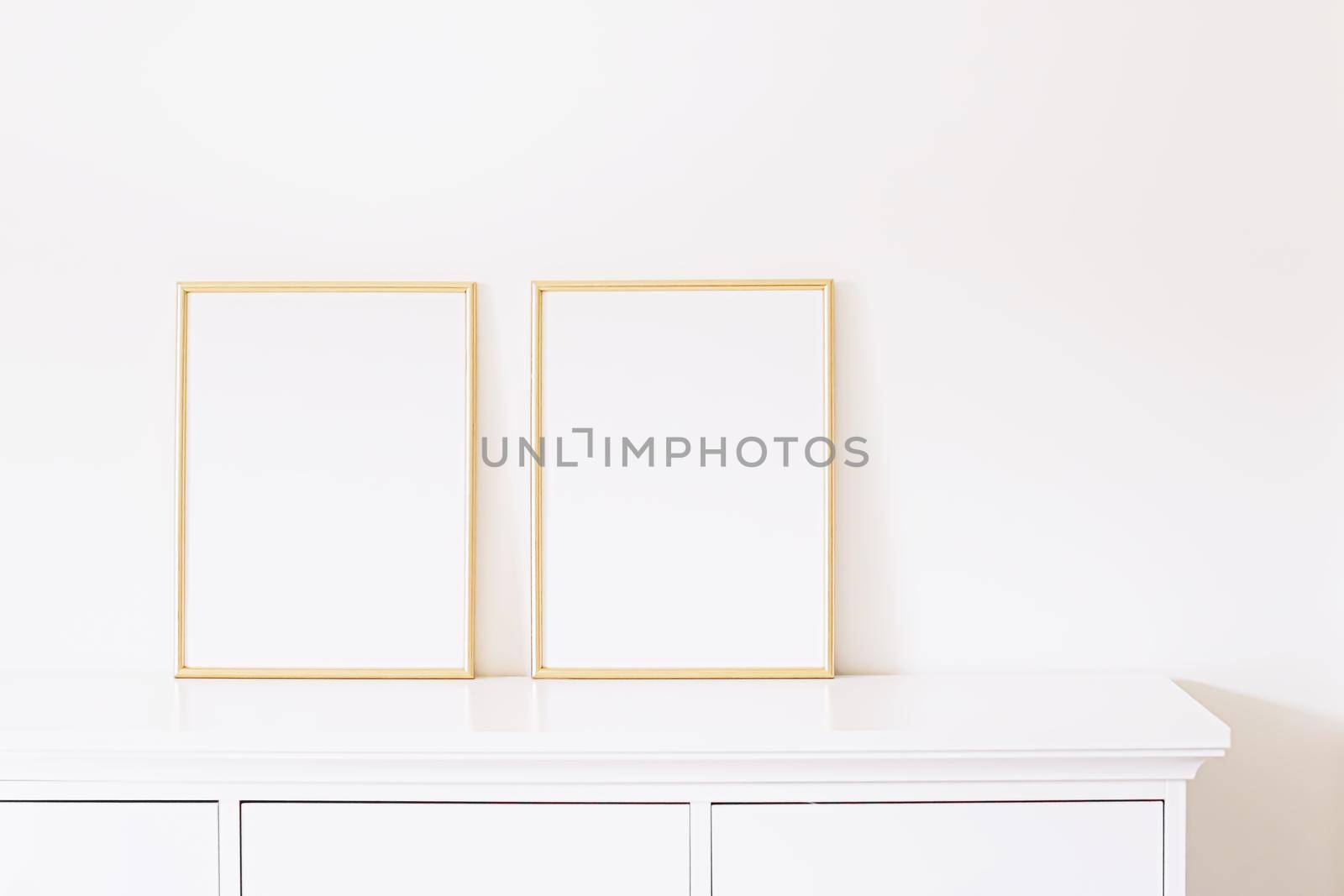 Two golden vertical frames on white furniture, luxury home decor and design for mockup creations