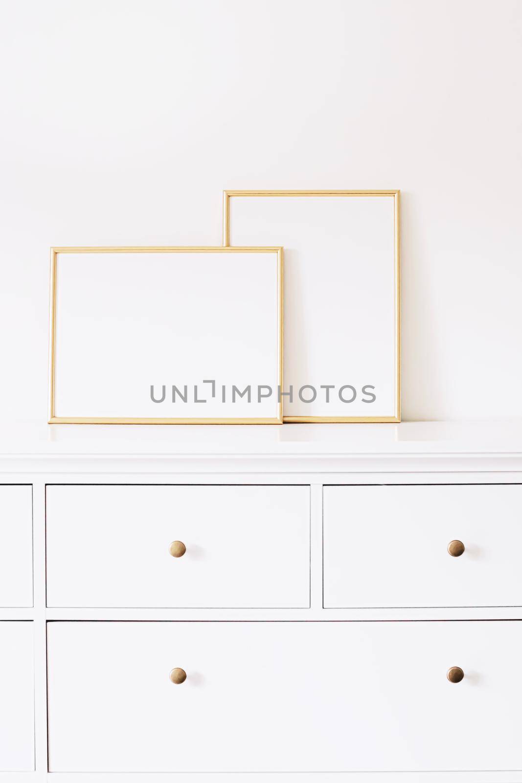 Two golden vertical and horizontal frames on white furniture, luxury home decor and design for mockup creations