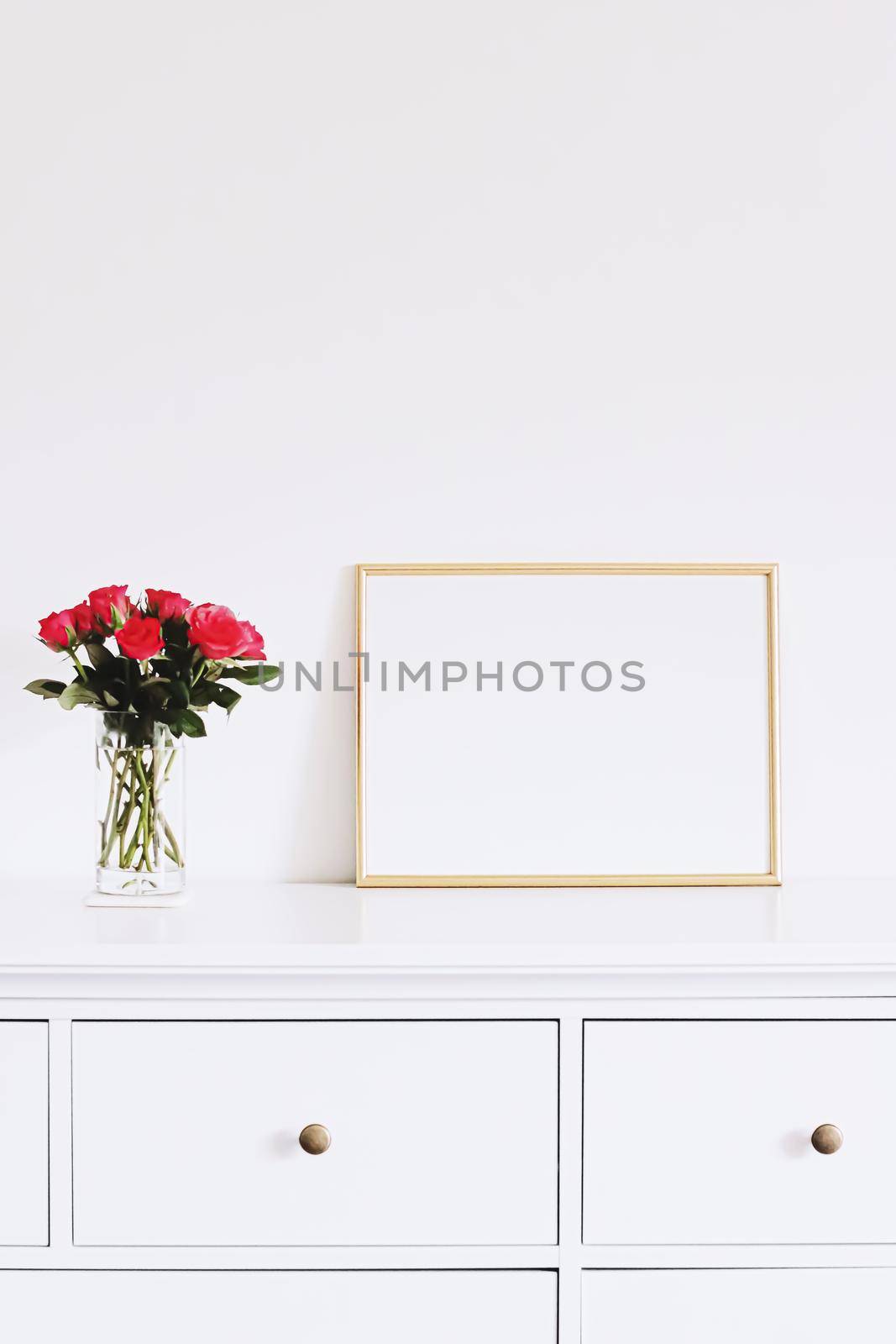 Golden horizontal frame and bouquet of rose flowers on white furniture, luxury home decor and design for mockup creations