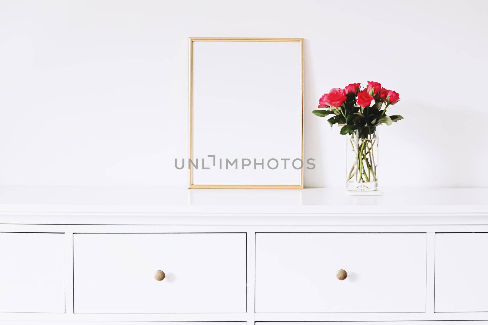 Golden horizontal frame and bouquet of rose flowers on white furniture, luxury home decor and design for mockup creations