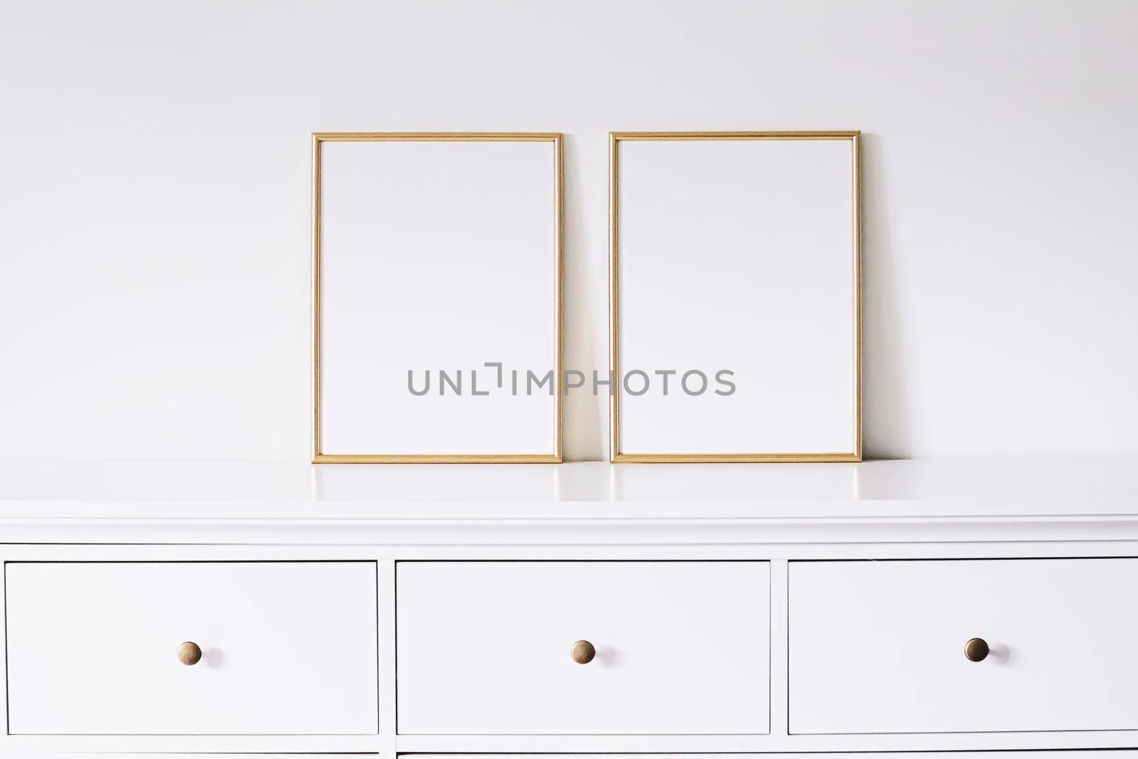 Two golden vertical frames on white furniture, luxury home decor and design for mockup creations