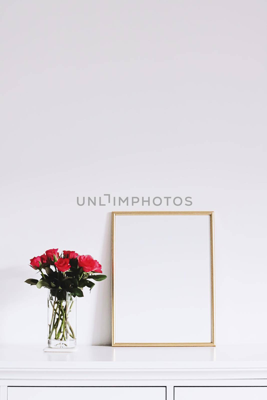 Golden horizontal frame and bouquet of rose flowers on white furniture, luxury home decor and design for mockup creations