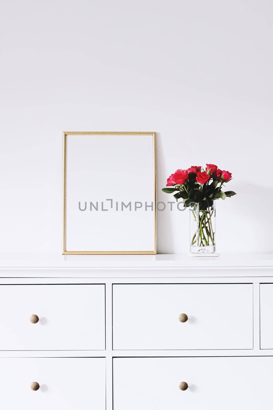 Golden horizontal frame and bouquet of rose flowers on white furniture, luxury home decor and design for mockup creations