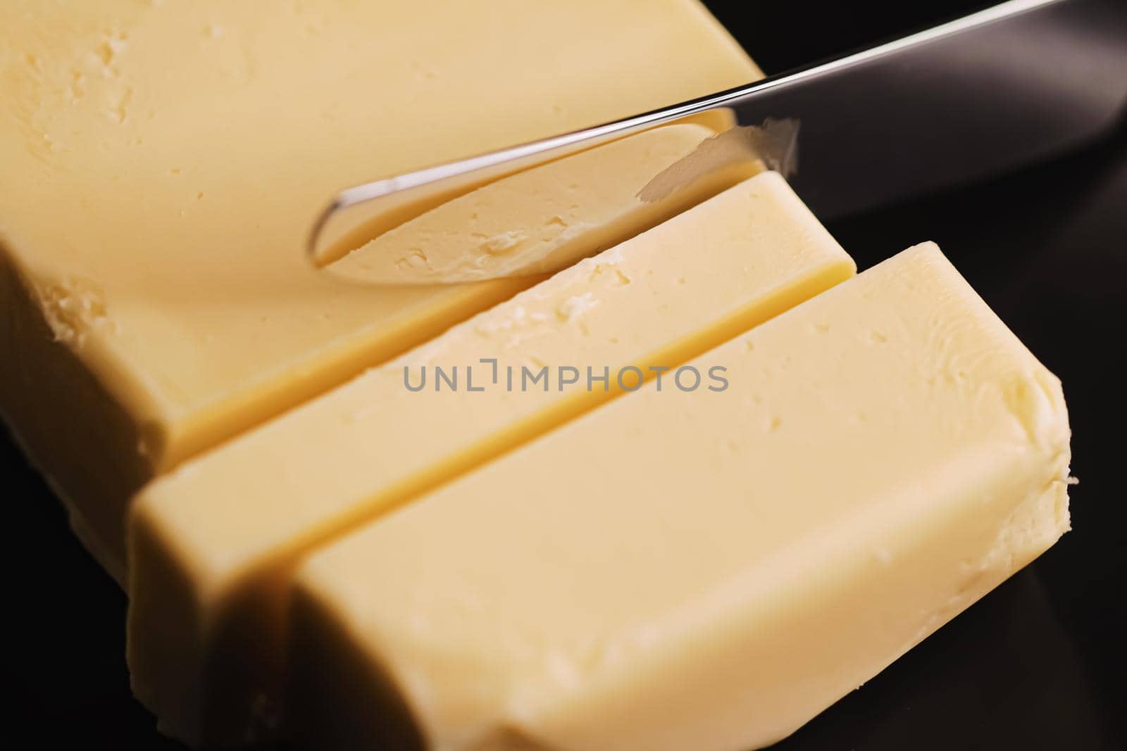 Sliced organic butter block and knife, breakfast food closeup