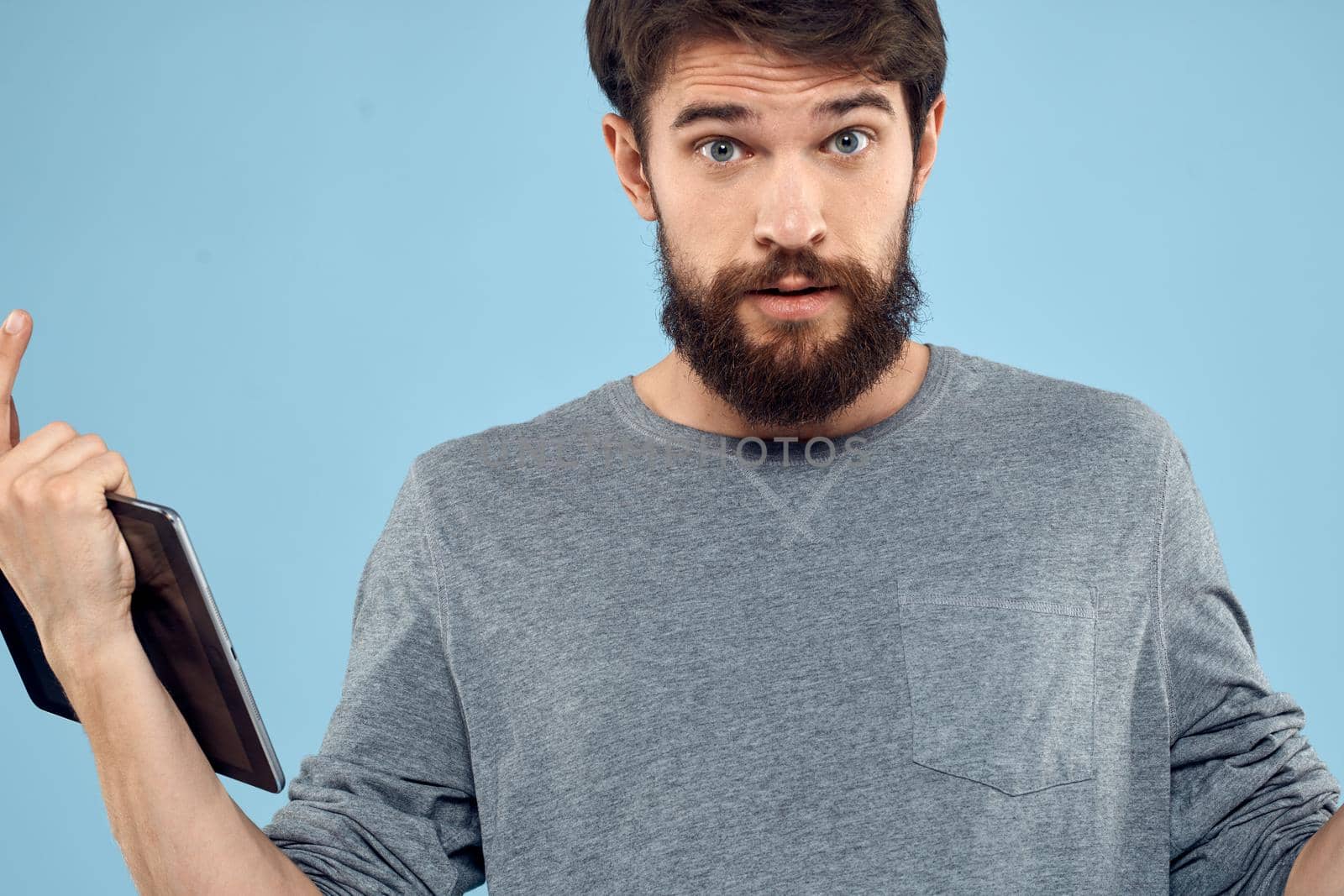 A man holding a tablet in the hands of a wireless device internet technology blue background. High quality photo