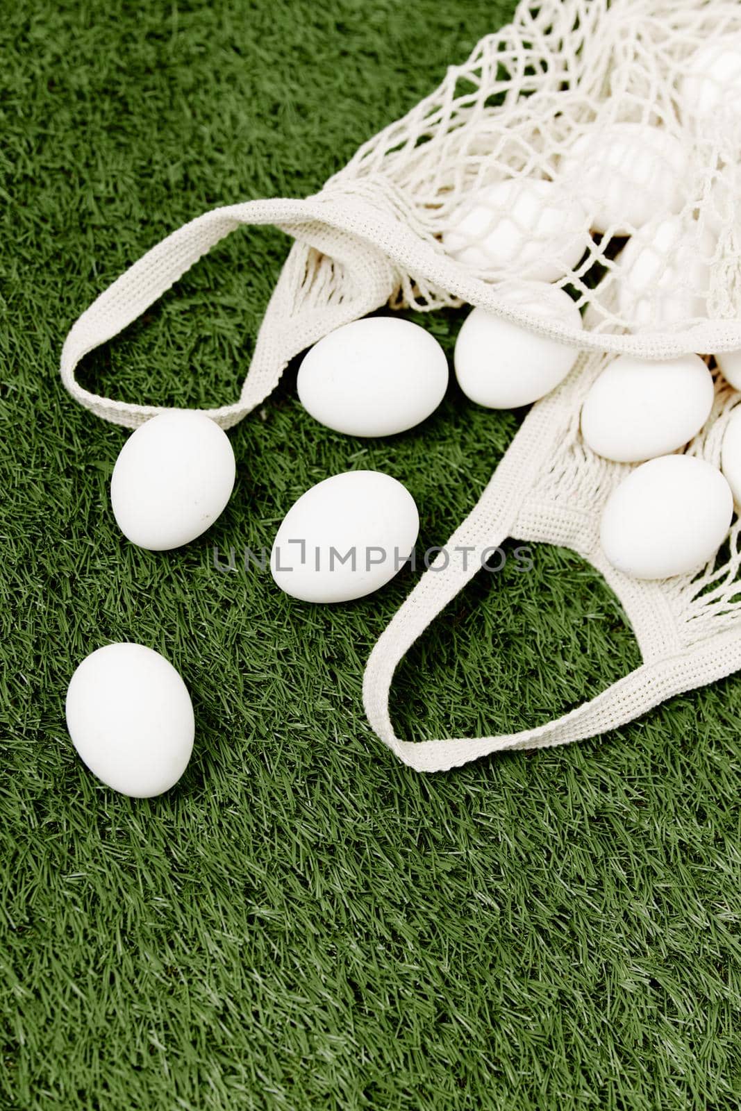 bag with white easter eggs lies on a green background holiday. High quality photo